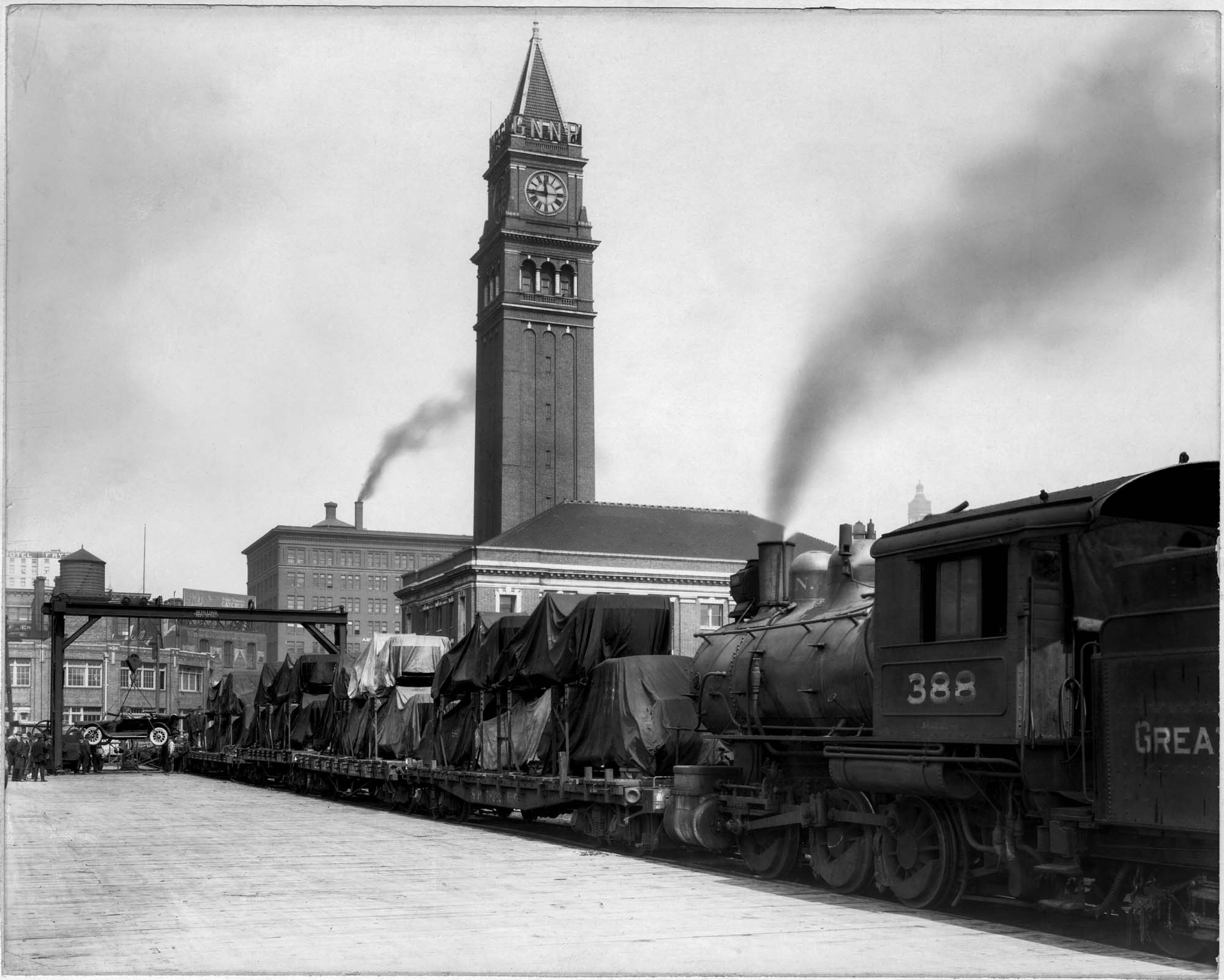 Image of Cars being unloaded from train at King Street Station, Seattle, circa 1915