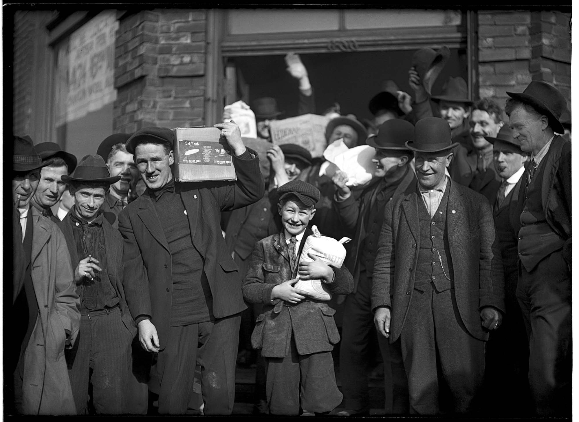 Image of A group of men and a boy carrying groceries during the Seattle general strike, February 7, 1919