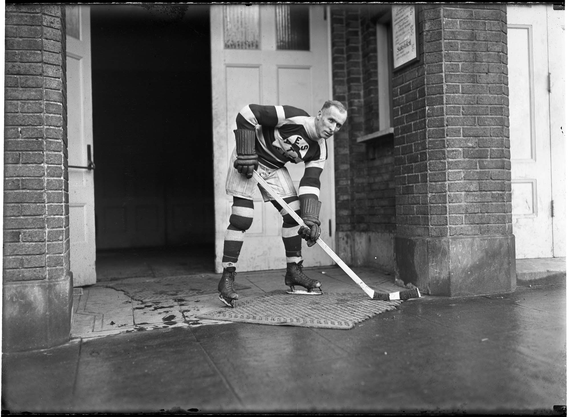 Image of Frank Foyston in hockey gear standing in doorway, Seattle, circa 1920