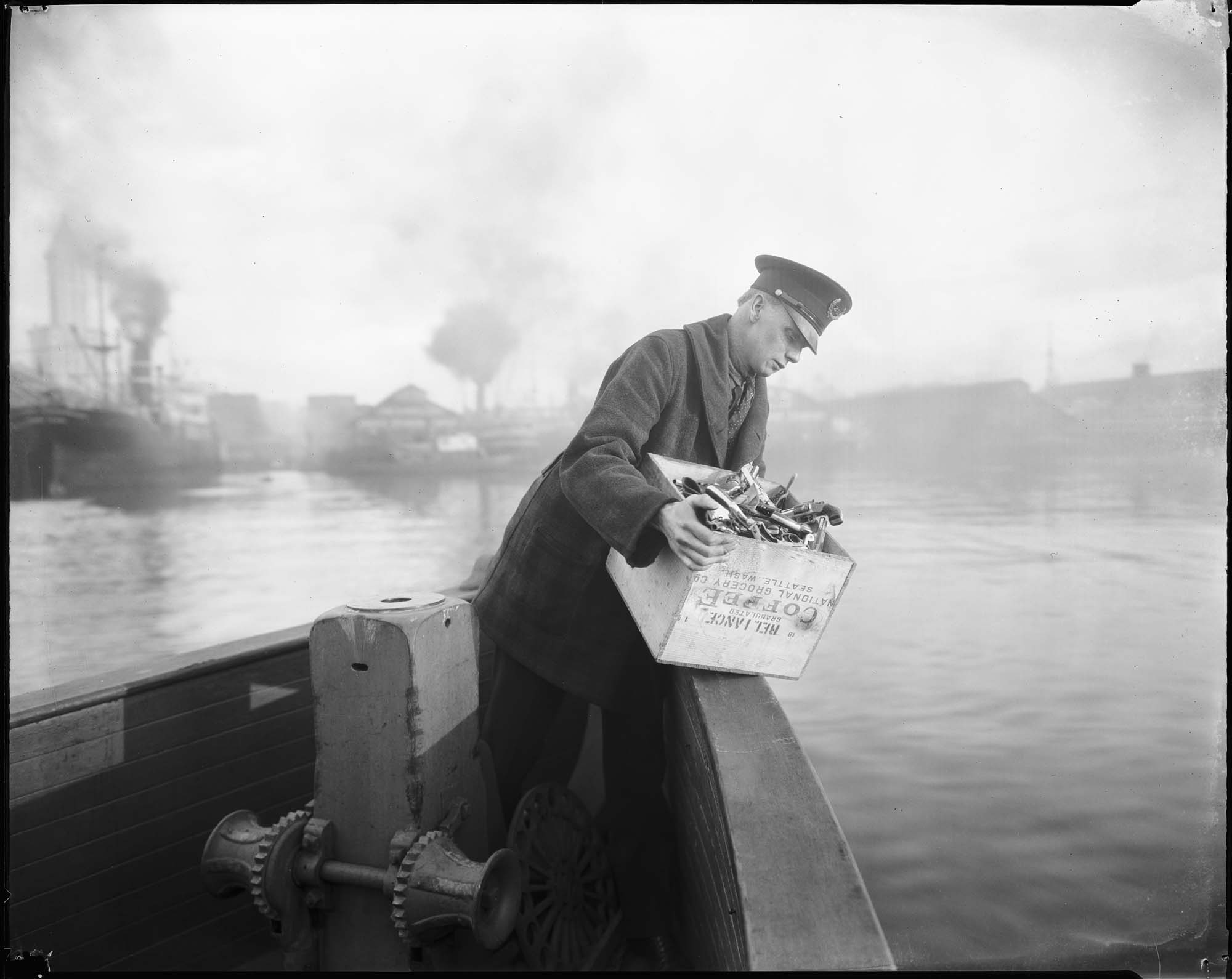 Image of Policeman disposing of firearms in Elliott Bay, circa 1922
