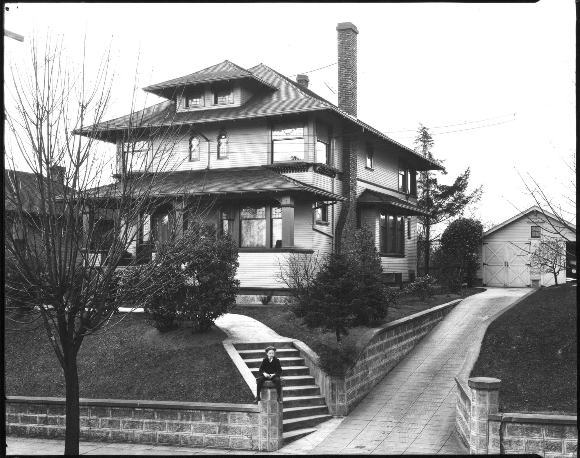 Image of Boy on post in front of house in Madrona neighborhood, Seattle, circa 1924