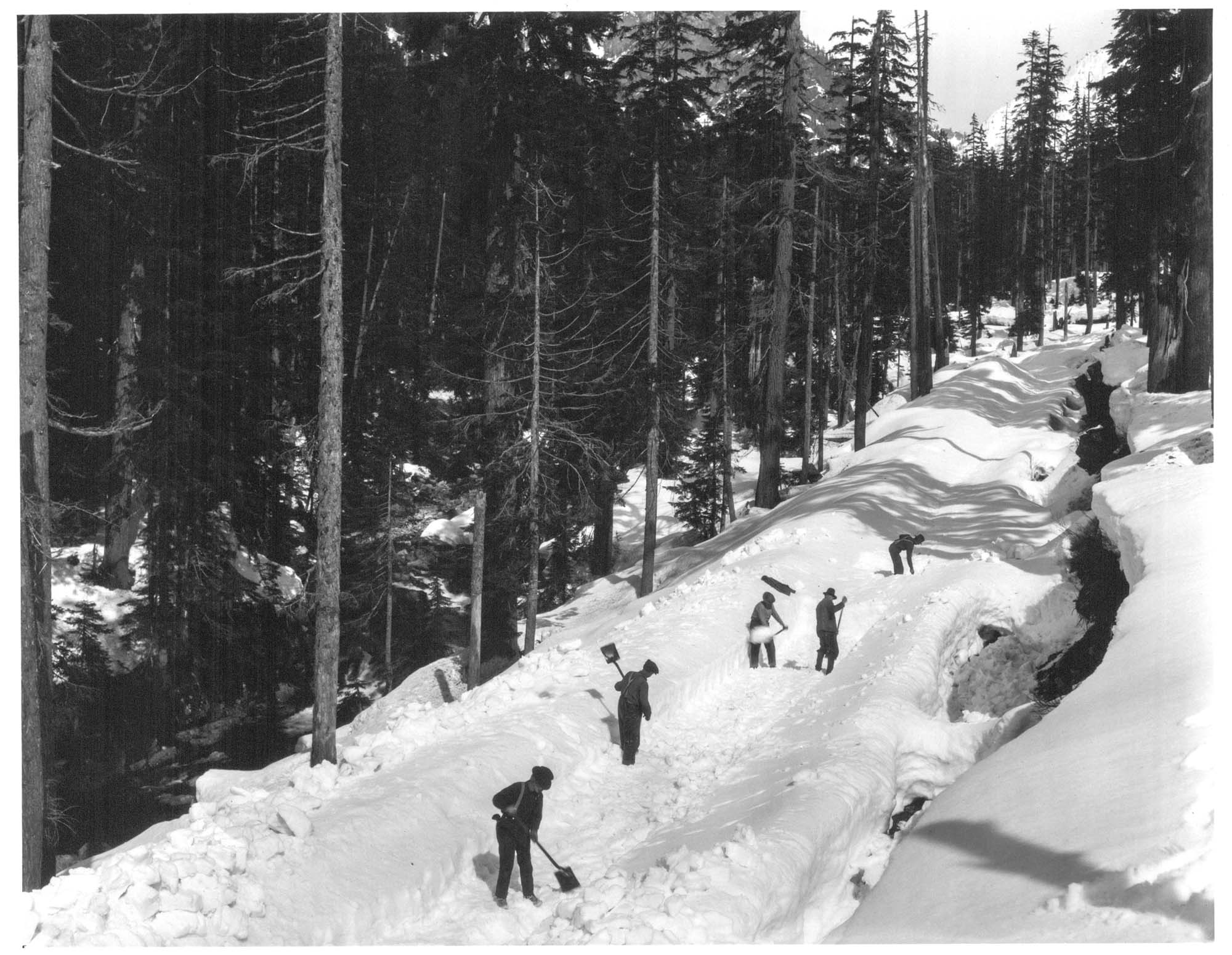 Image of Workers shoveling snow at Snoqualmie Pass, circa 1923