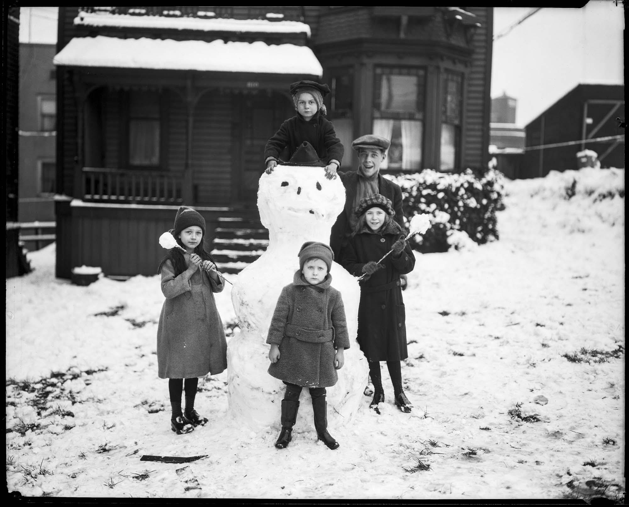 Image of Children and their champion snowman, November 20, 1921