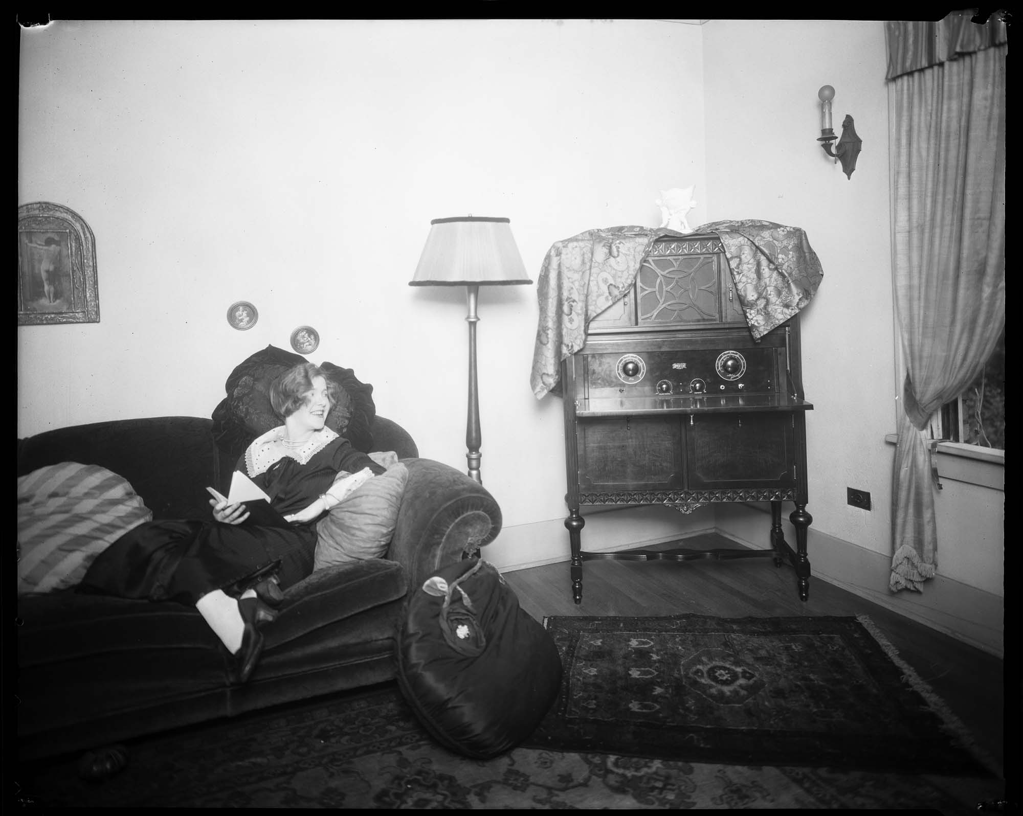 Image of Woman listening to a radio in her living room, circa 1926