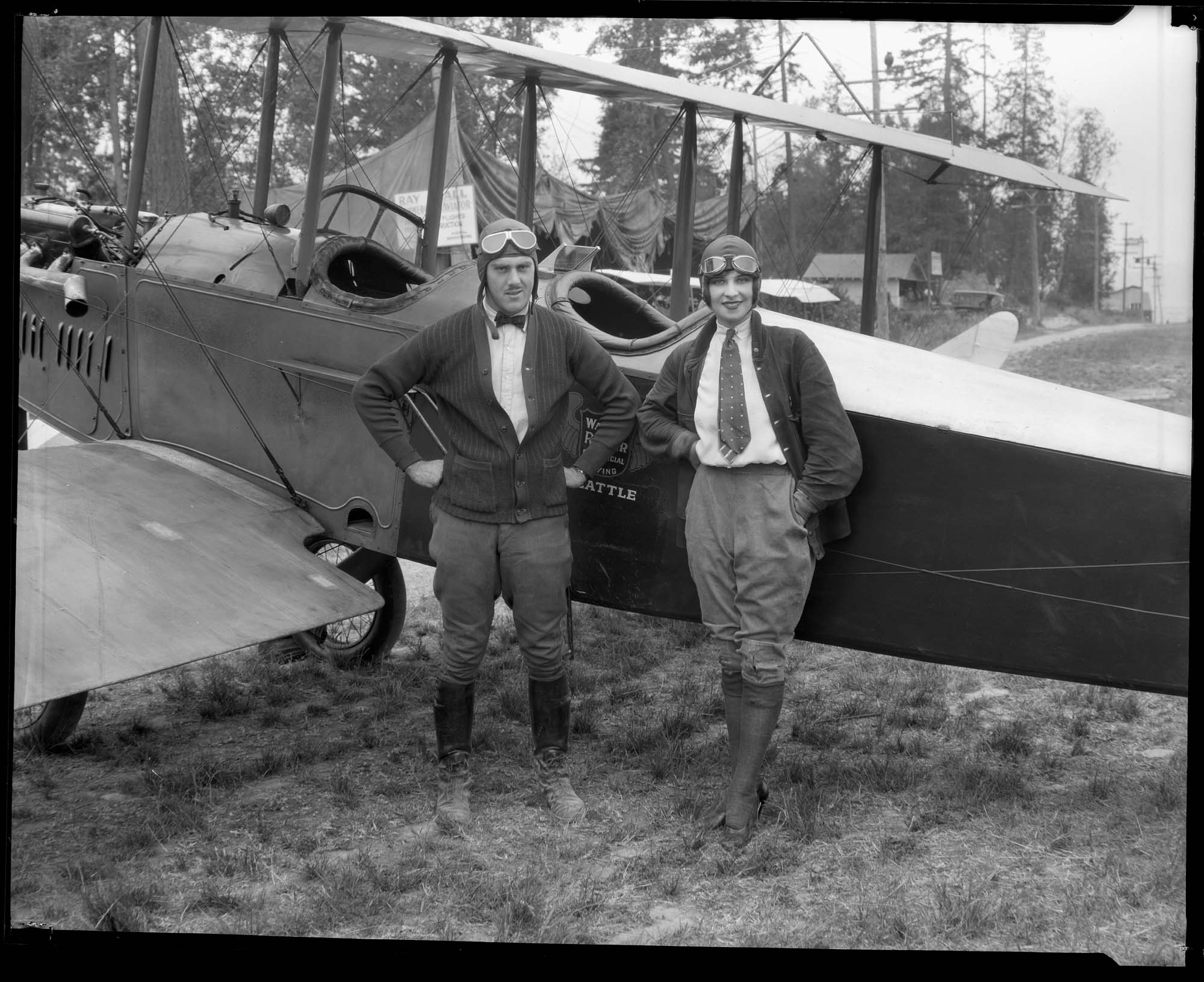 Image of Miss Seattle poses with biplane and pilot at Sand Point, 1926
