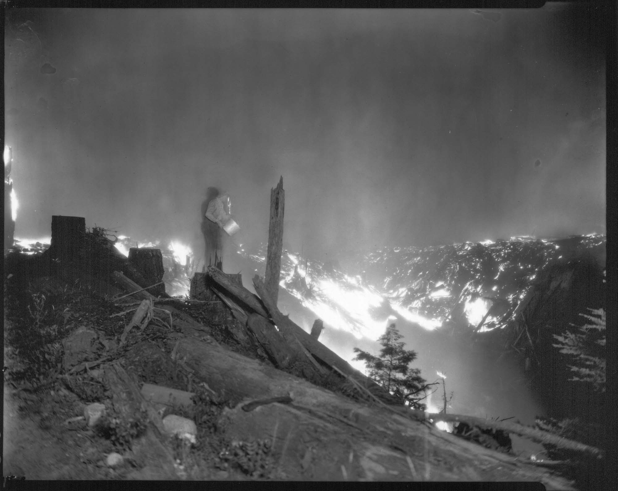 Image of Man with bucket at forest fire, circa 1926