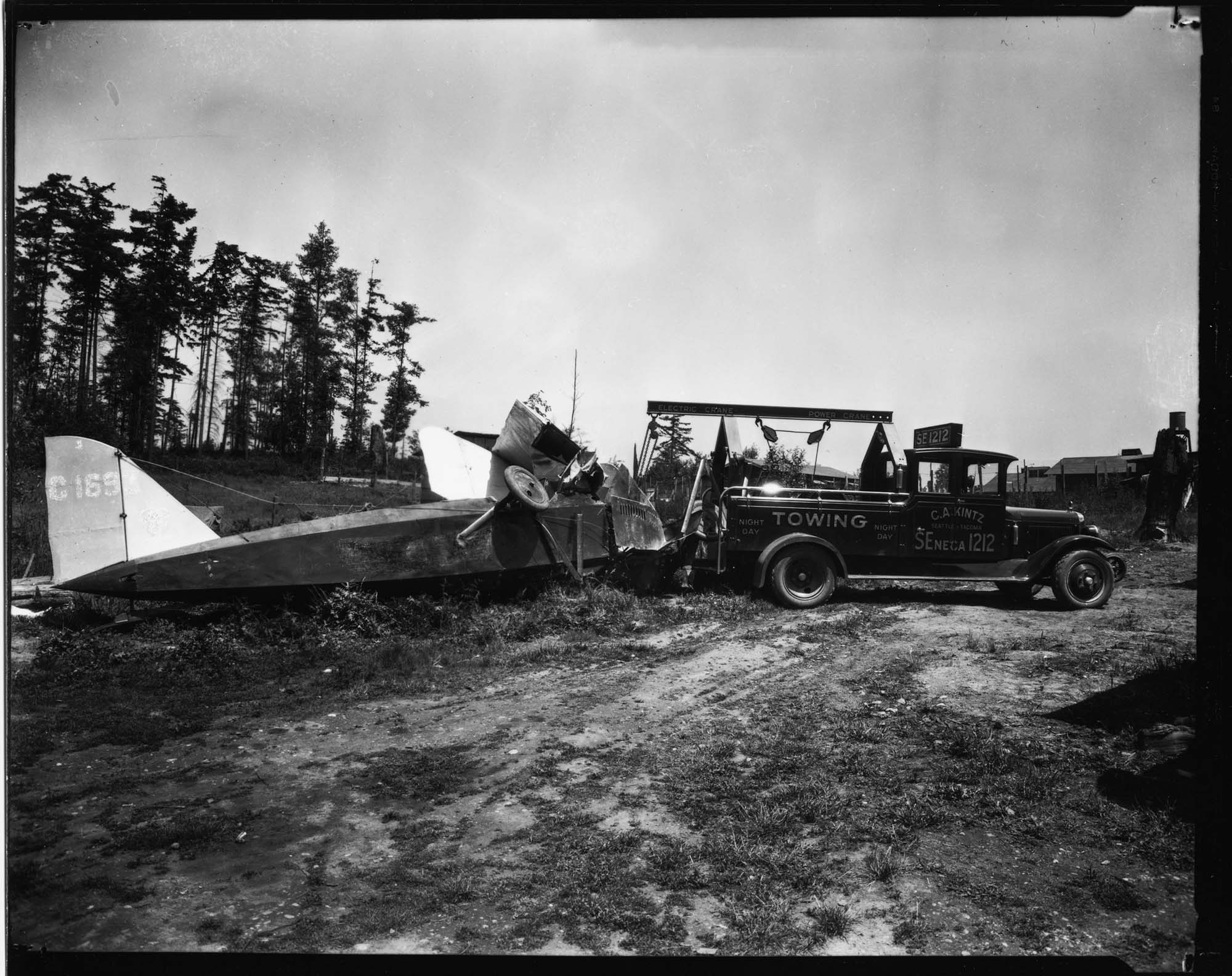 Image of Truck towing crashed plane, June 24, 1929