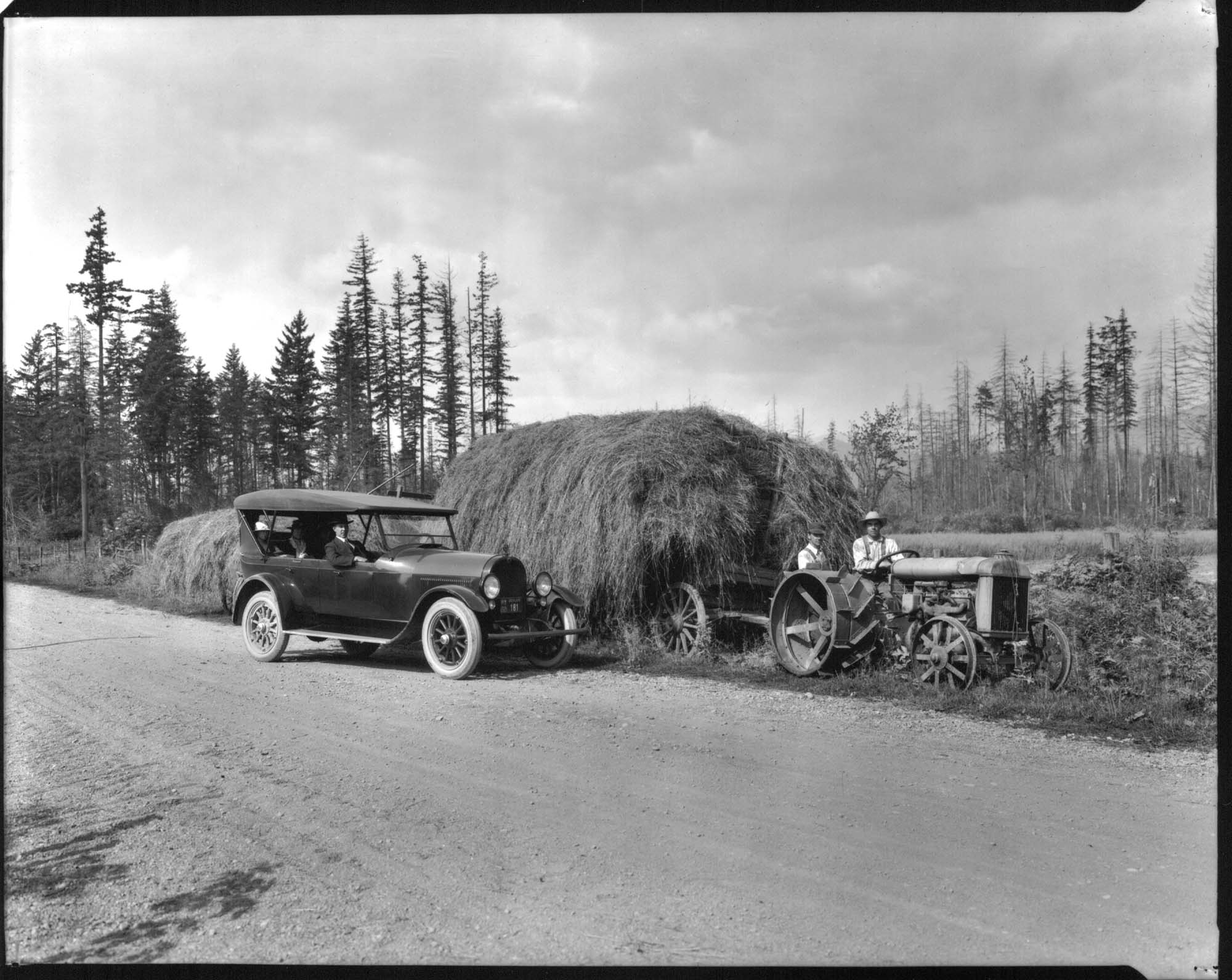 Image of Car near tractor with load of hay, 1921
