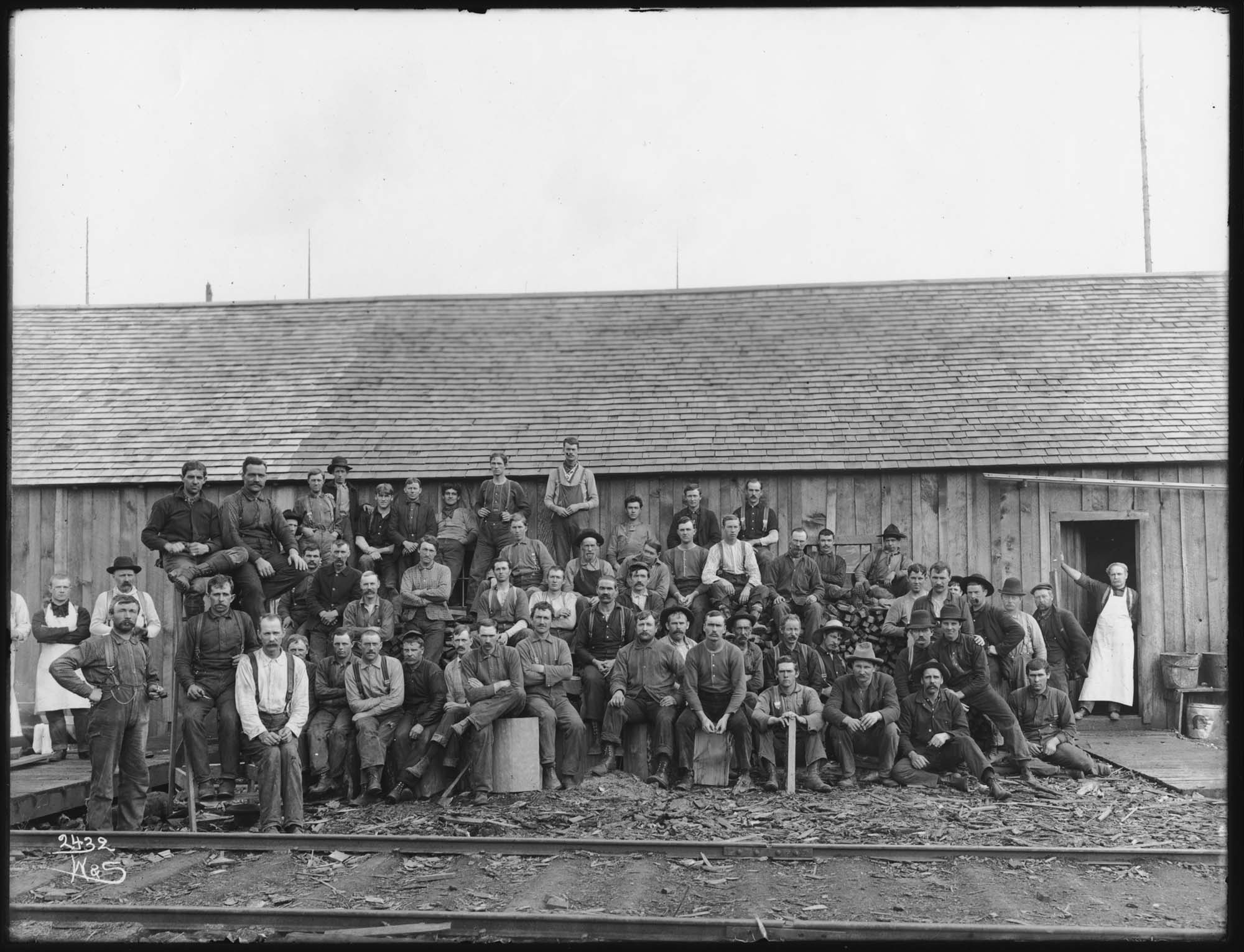Image of Loggers outside bunkhouse, circa 1911