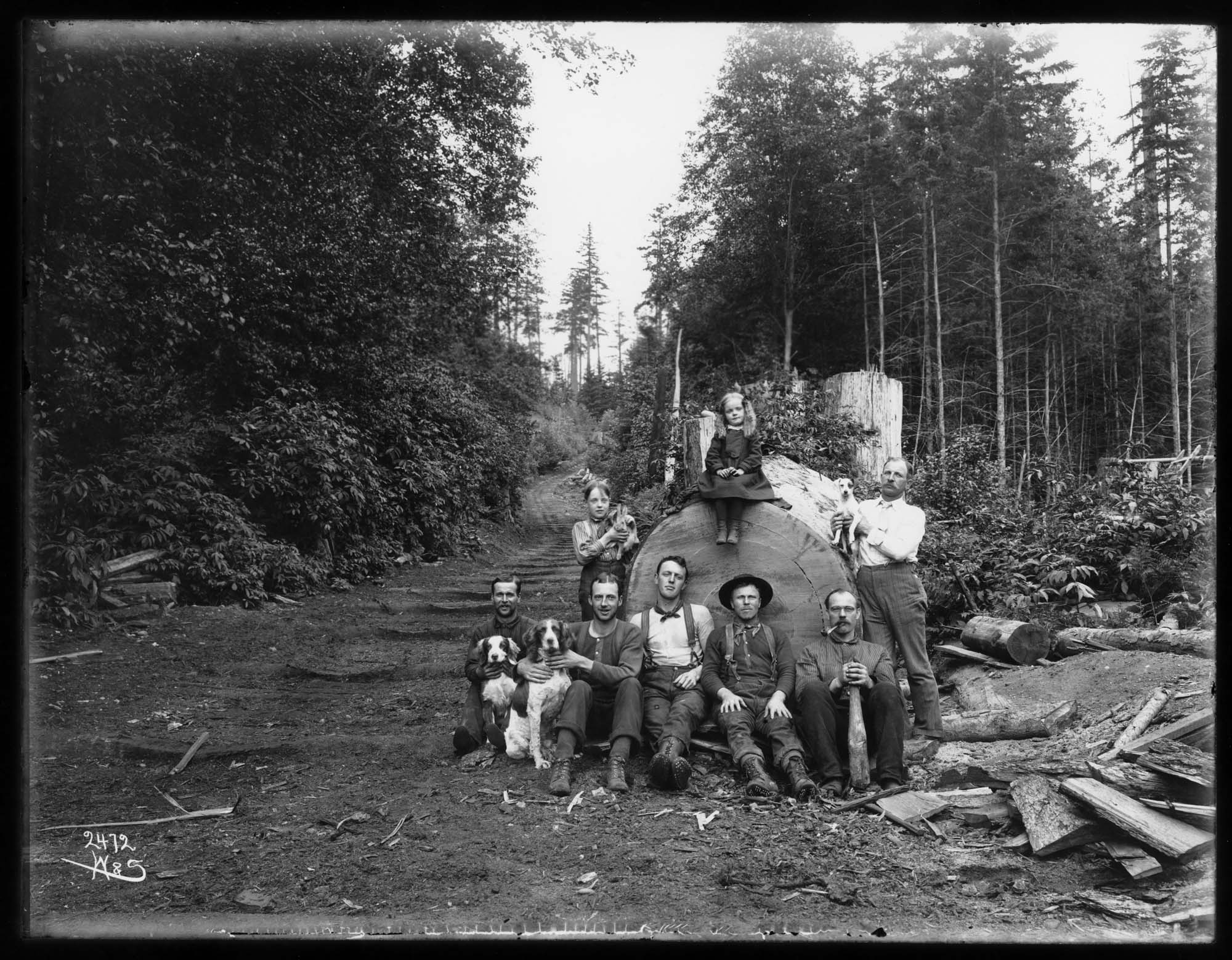 Image of Children and logging crew with a big log, circa 1903