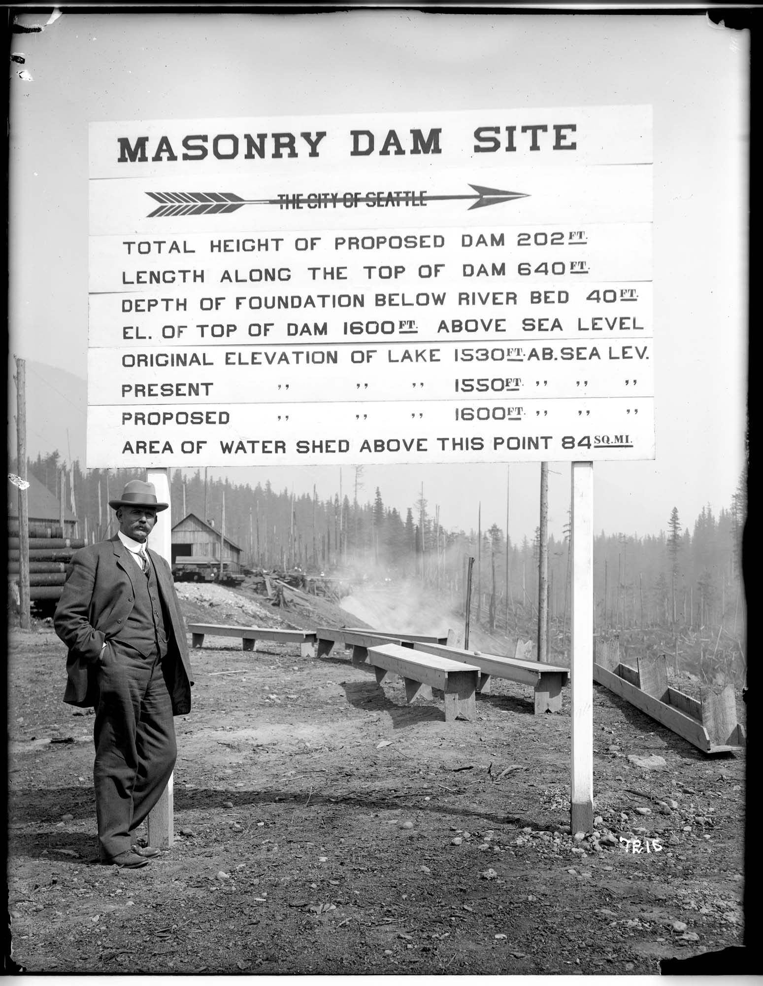 Image of City Engineer R.H. Thomson and sign for new dam, circa 1912