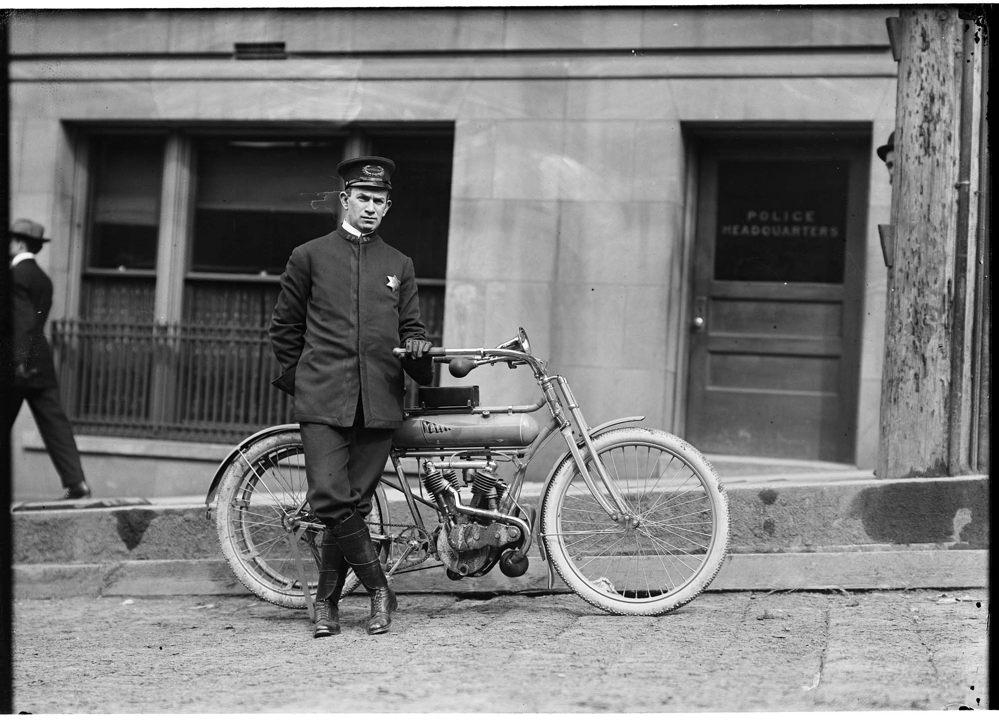 Image of Motorcycle police officer posing with bike, Seattle, circa 1915