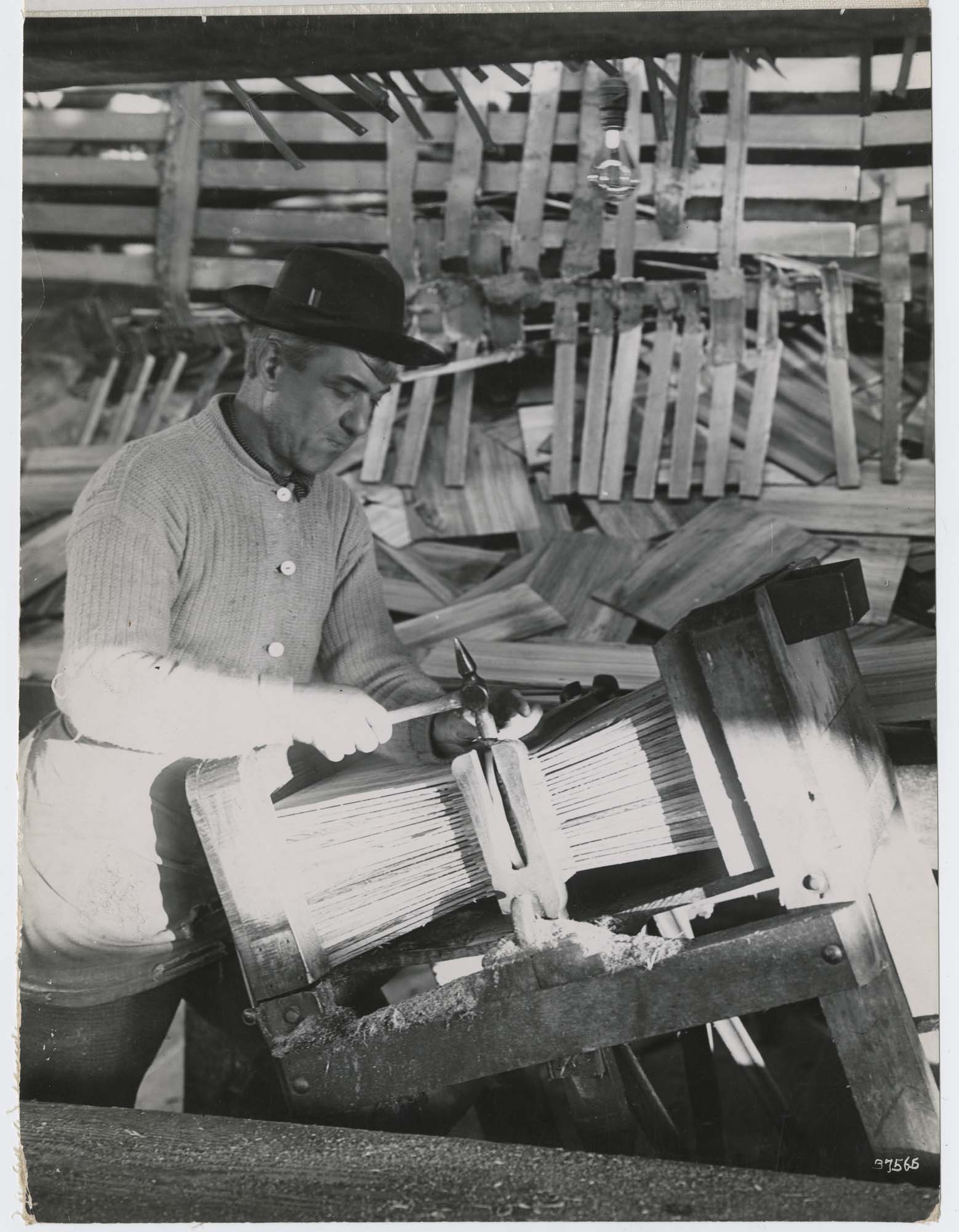 Image of Man nailing a bundle of shingles, circa 1915
