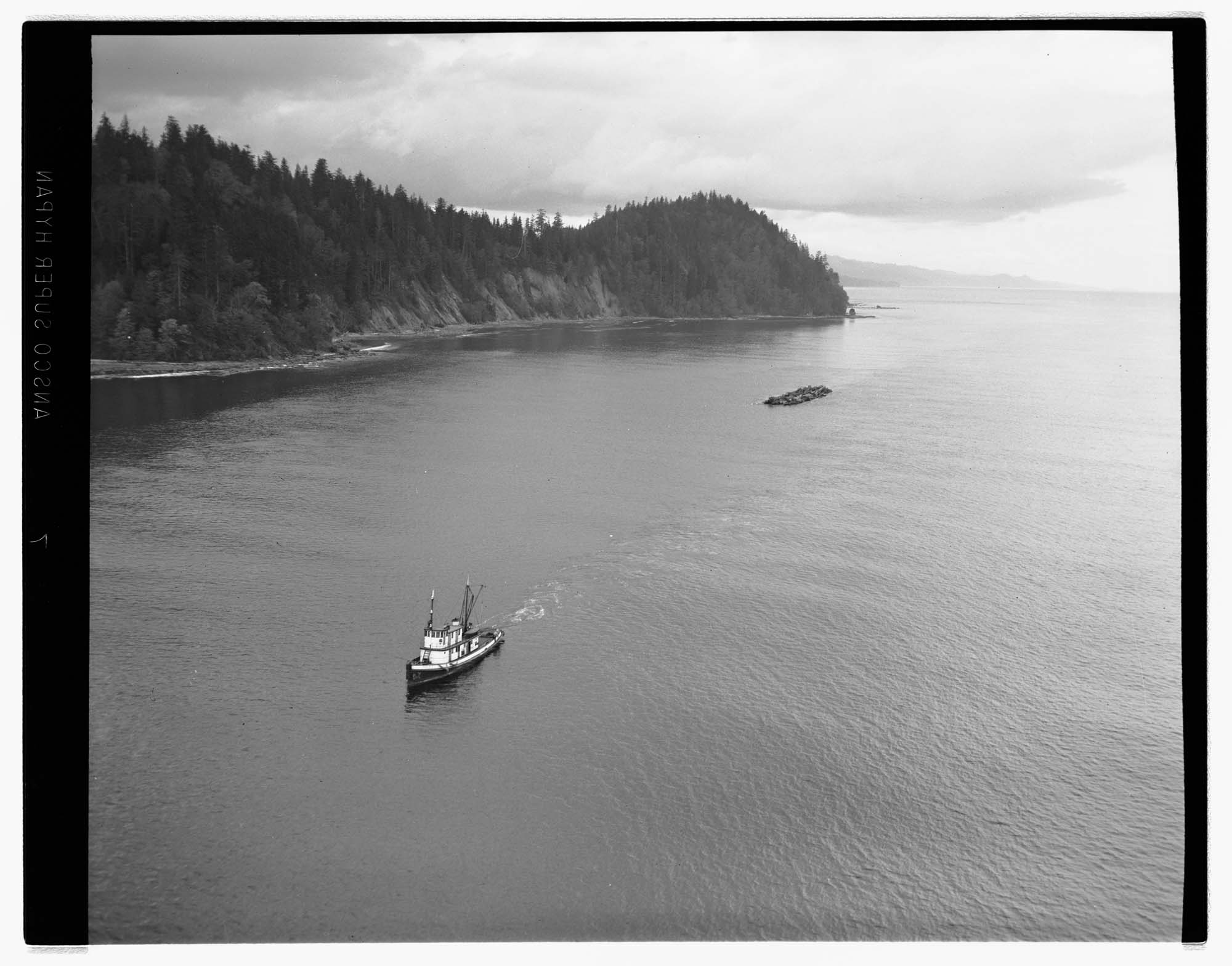 Image of Aerial view of Washington State coast, with a tugboat pulling logs, 1959