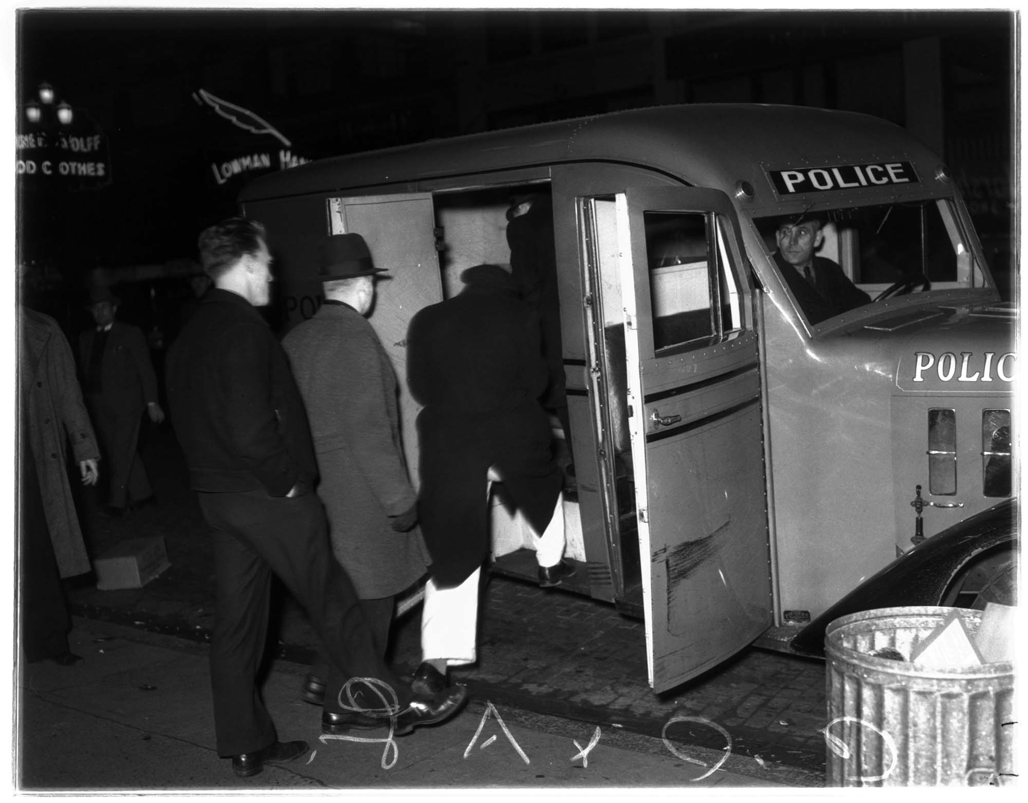 Image of Men being loaded into a police paddy wagon, Seattle, 1936