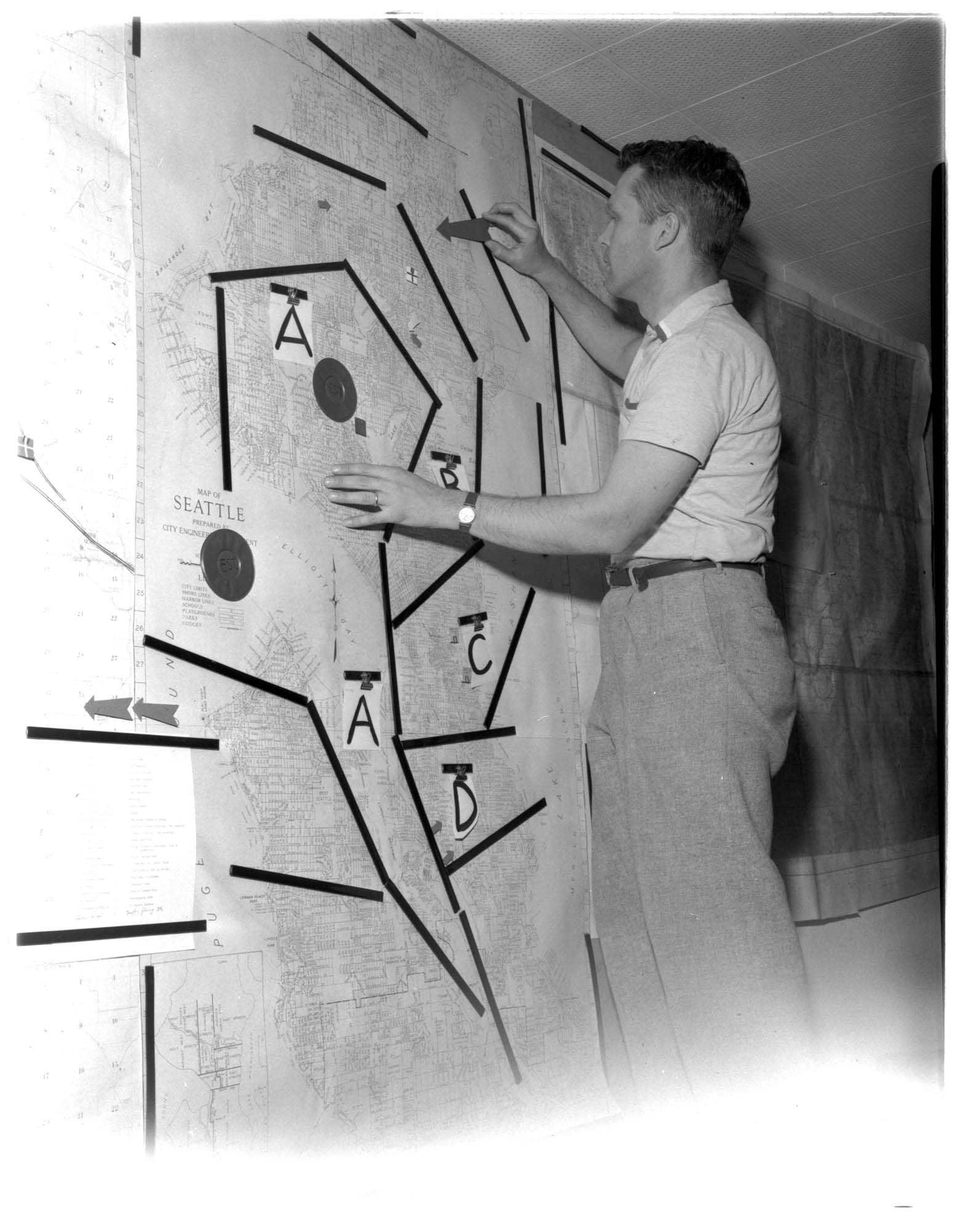 Image of Man with civil defense map of Seattle, 1958