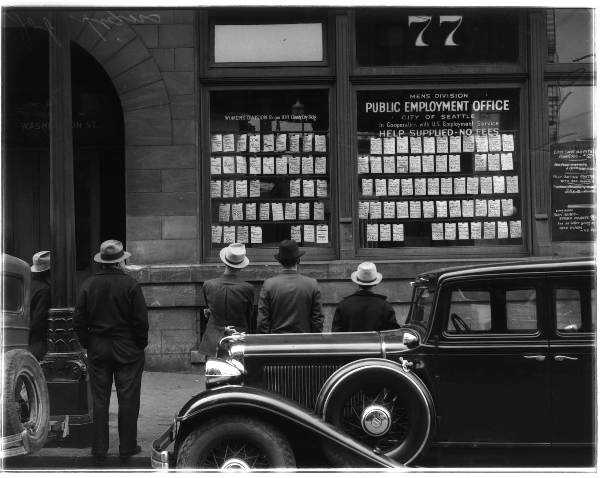Image of Men looking at listings posted in the window of the Public Employment Office, Seattle, 1936