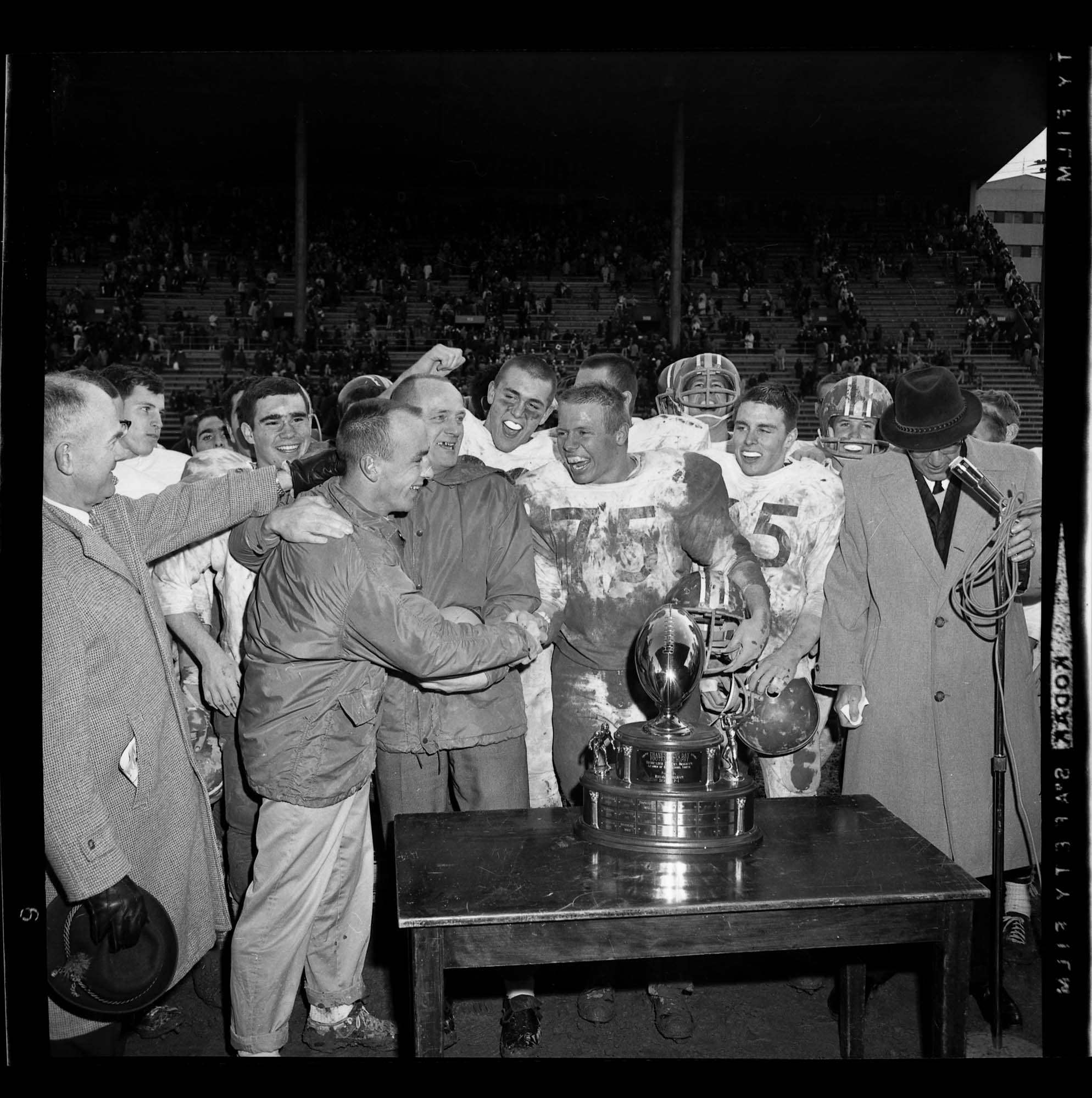 Image of Roosevelt High School football team getting trophy after beating Garfield, Seattle, 1964