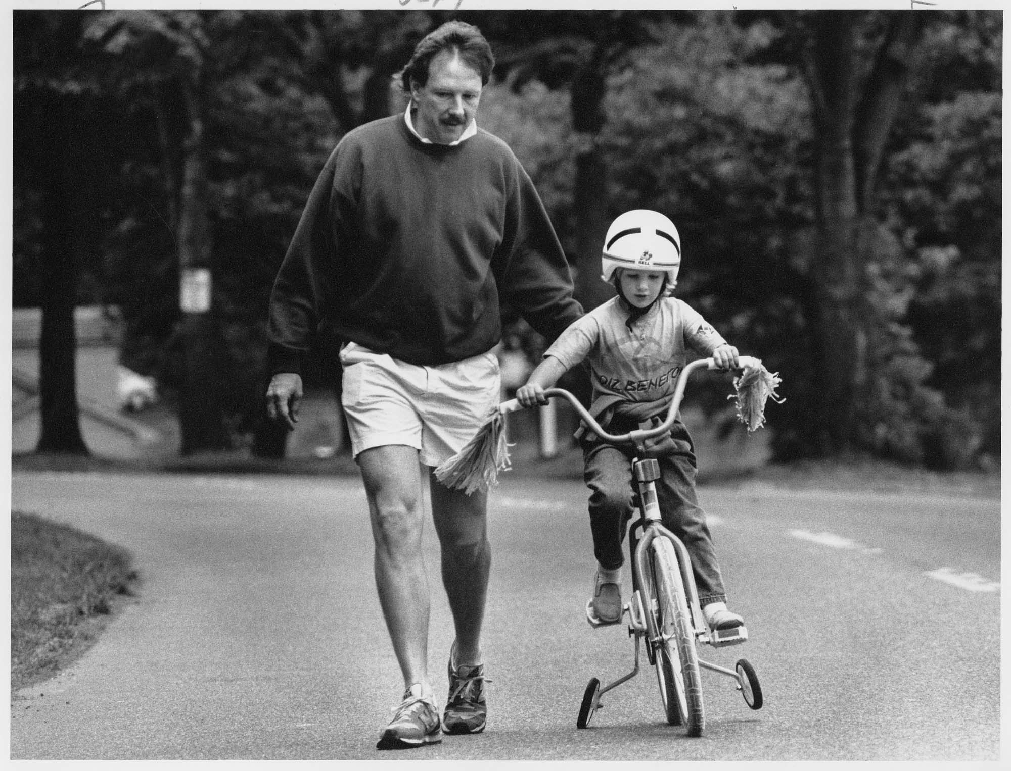 Image of Father teaching his daughter to ride a bicycle, Seattle, June 18, 1989