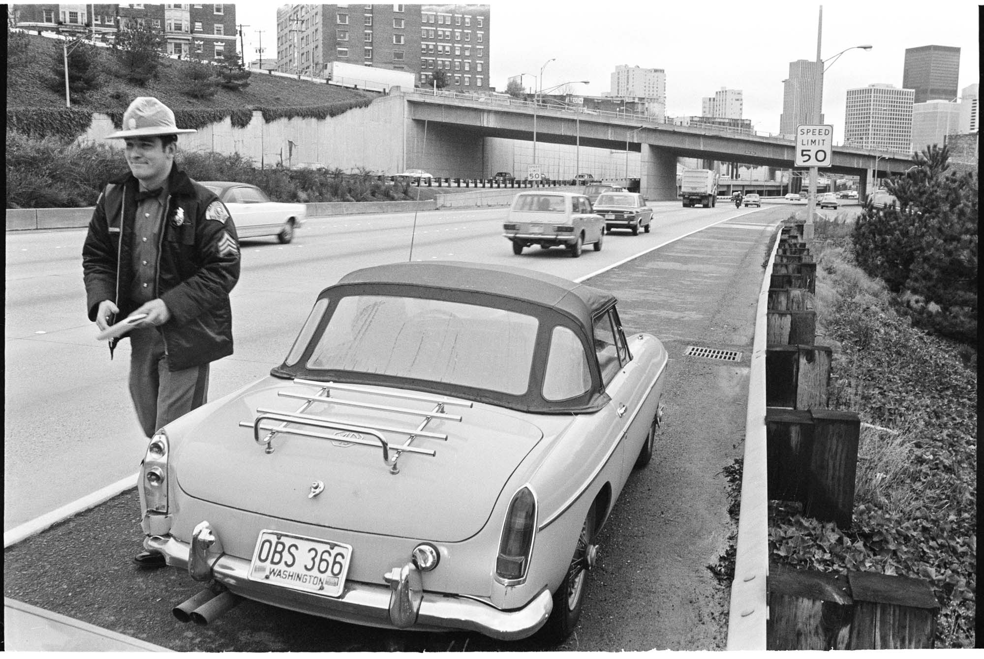 Image of State Patrol officer issuing ticket under new 50 MPH speed limit, Seattle,  November 1973