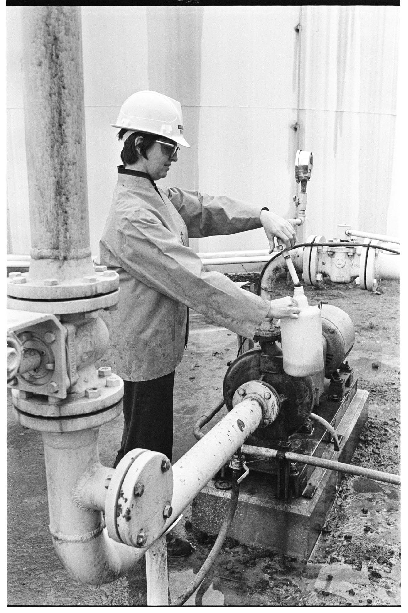 Image of Juanita Collins, chemical engineer, taking a sample for testing at the Monsanto plant, Seattle, December 16, 1973