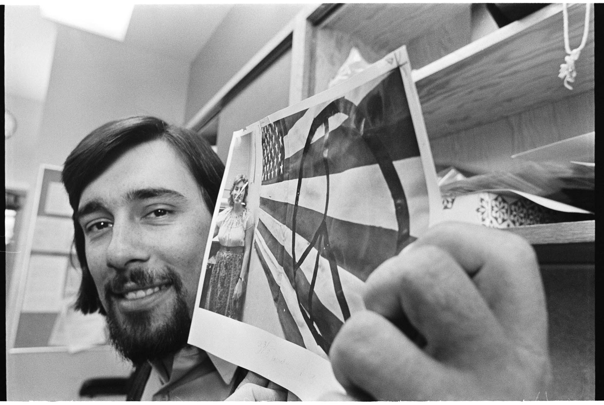 Image of Harold Spence with a photo of his controversial peace symbol flag, June 28, 1974
