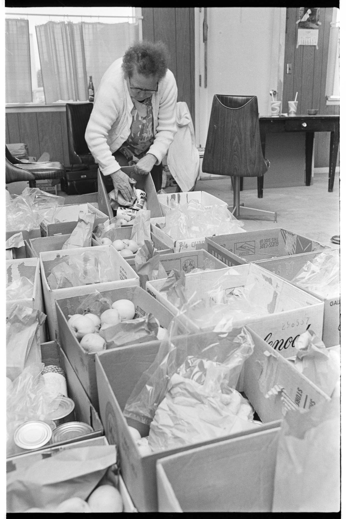 Image of Margaret Jensen, coordinator at South Park food bank, with boxes of food, Seattle, February 4, 1975