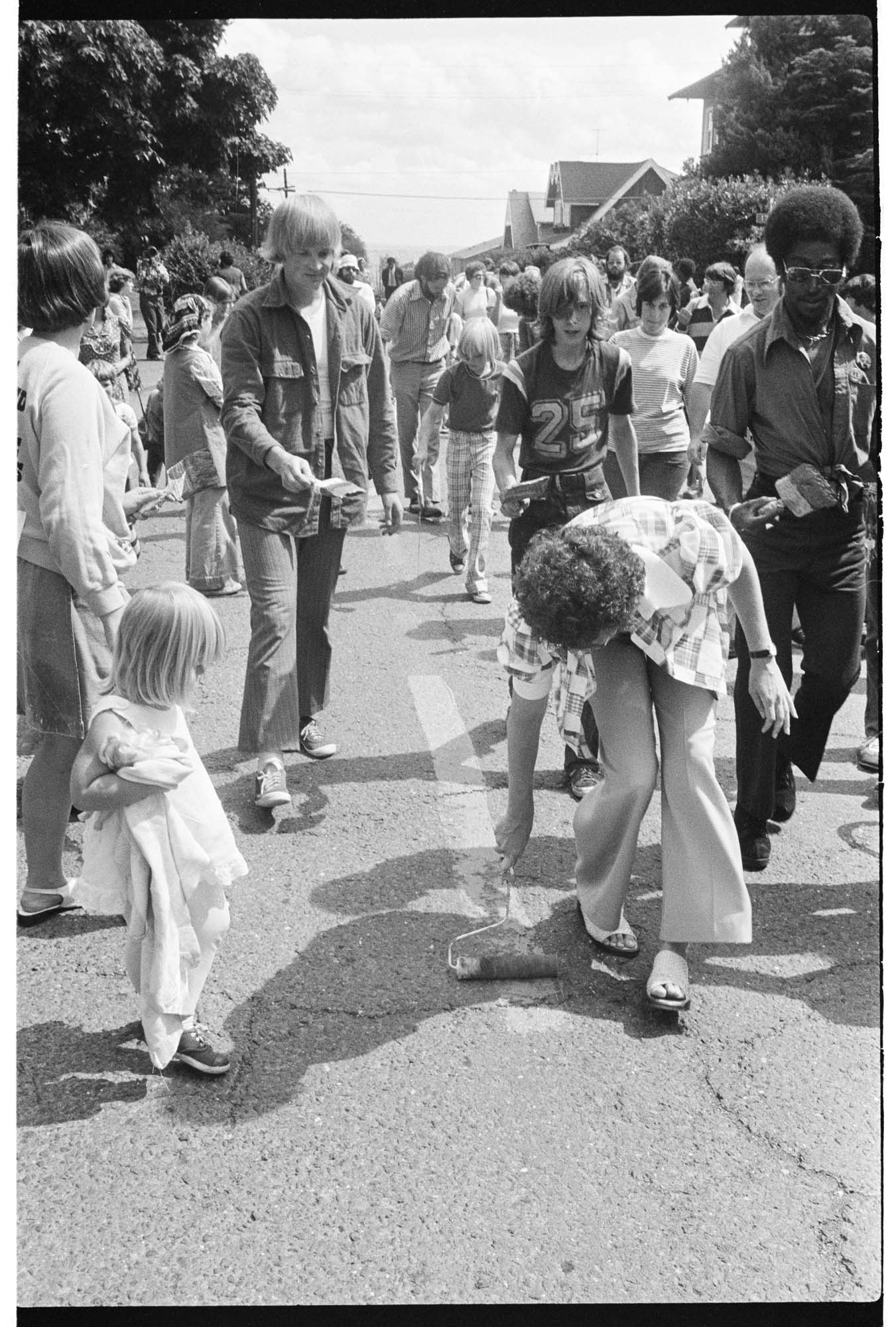 Image of Central Area residents painting a red line down the middle of Roy Street to protest red-lining bank policies, August 17, 1975