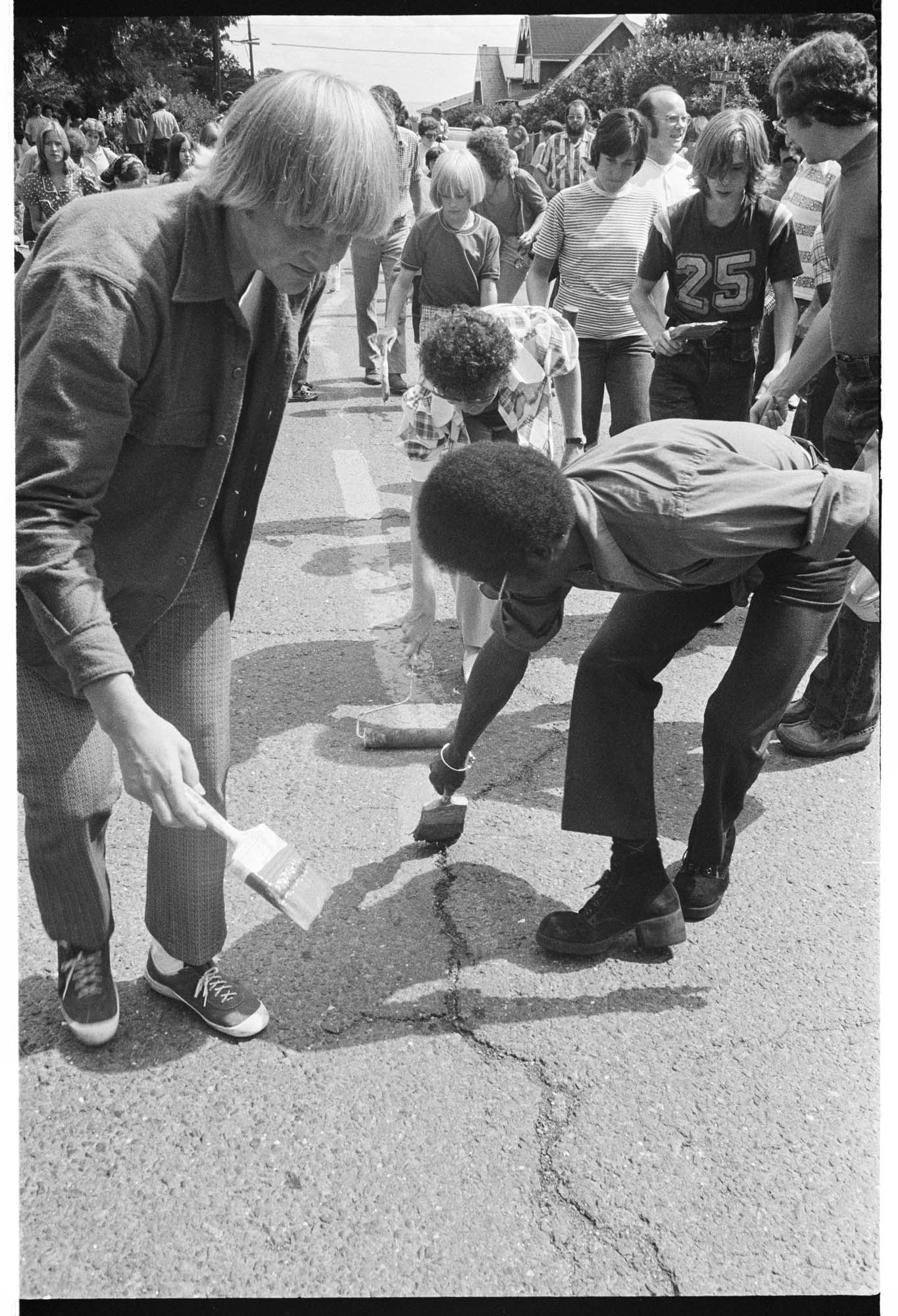 Image of Central Area residents painting a red line down the middle of Roy Street to protest red-lining bank policies, August 17, 1975