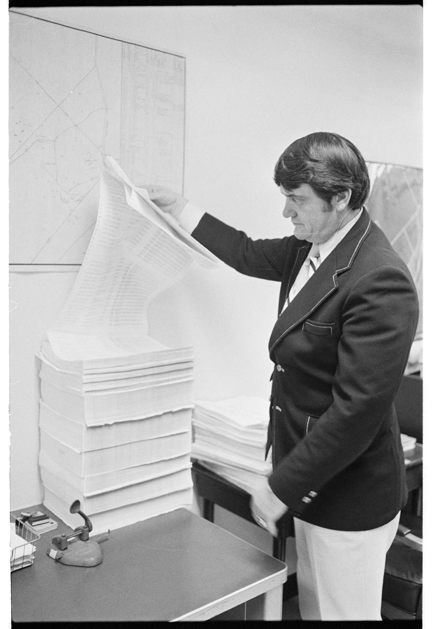 Image of King County Det. Capt. Nick Mackie with computer printouts related to 