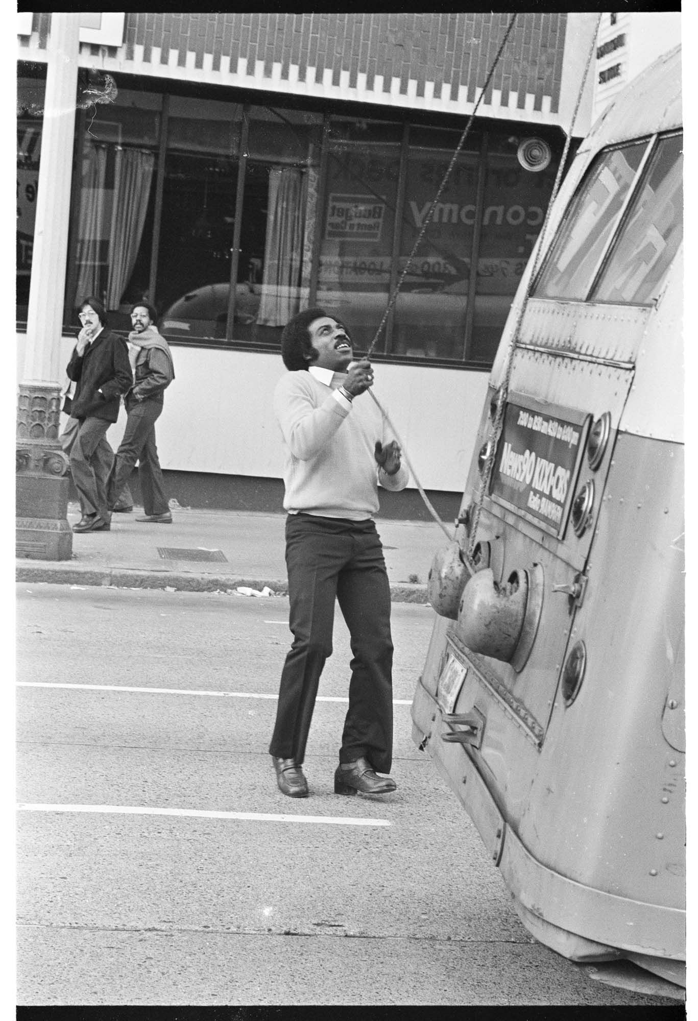Image of Curtis Robinson checking the power poles of his Metro trolley bus, Seattle, November 1975
