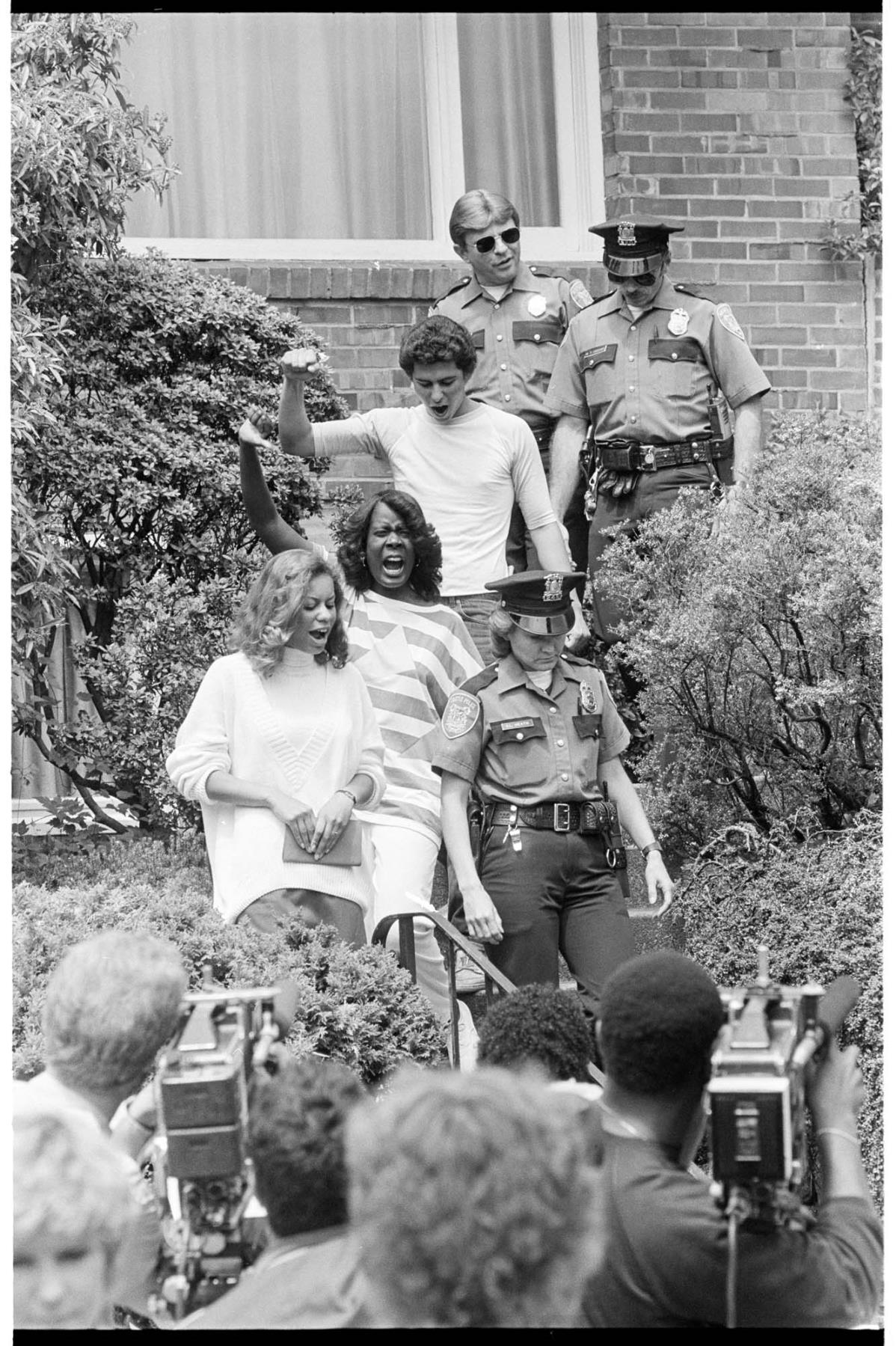 Image of Police escorting three protesters from the South African consulate, Seattle, June 14, 1986