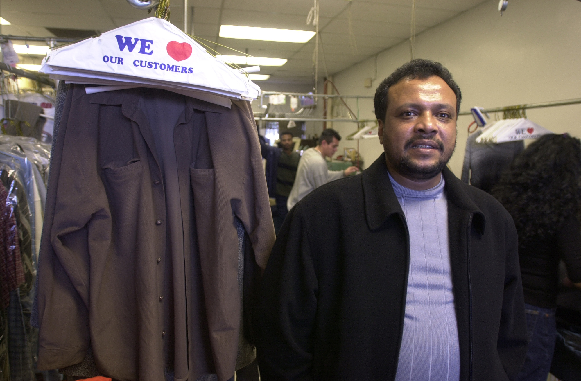 Image of Soud Kirat, owner of Fine Cleaners, in his store, December 31, 2002