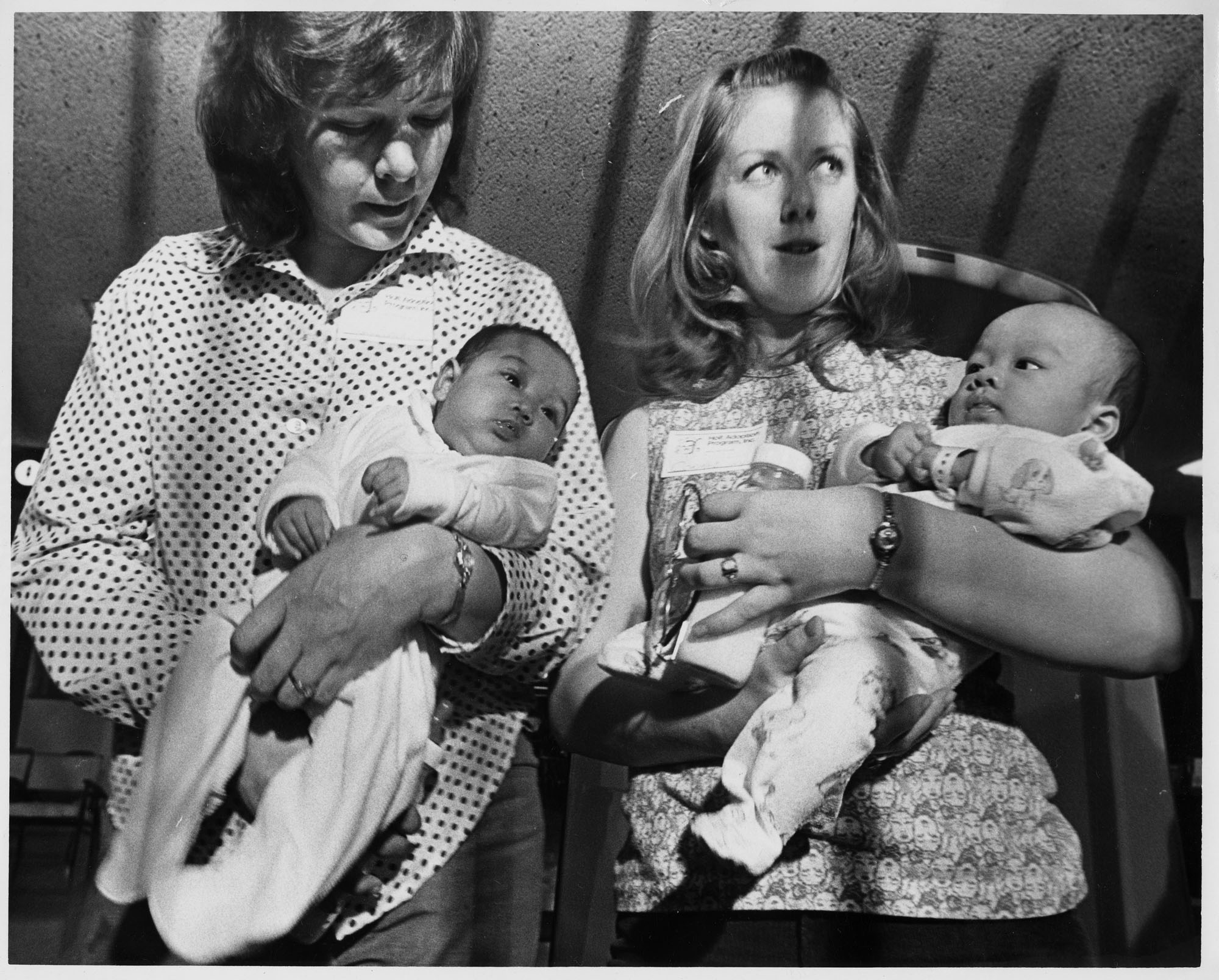 Image of Two women holding Vietnamese infants at Sea-Tac Airport, April 6, 1975