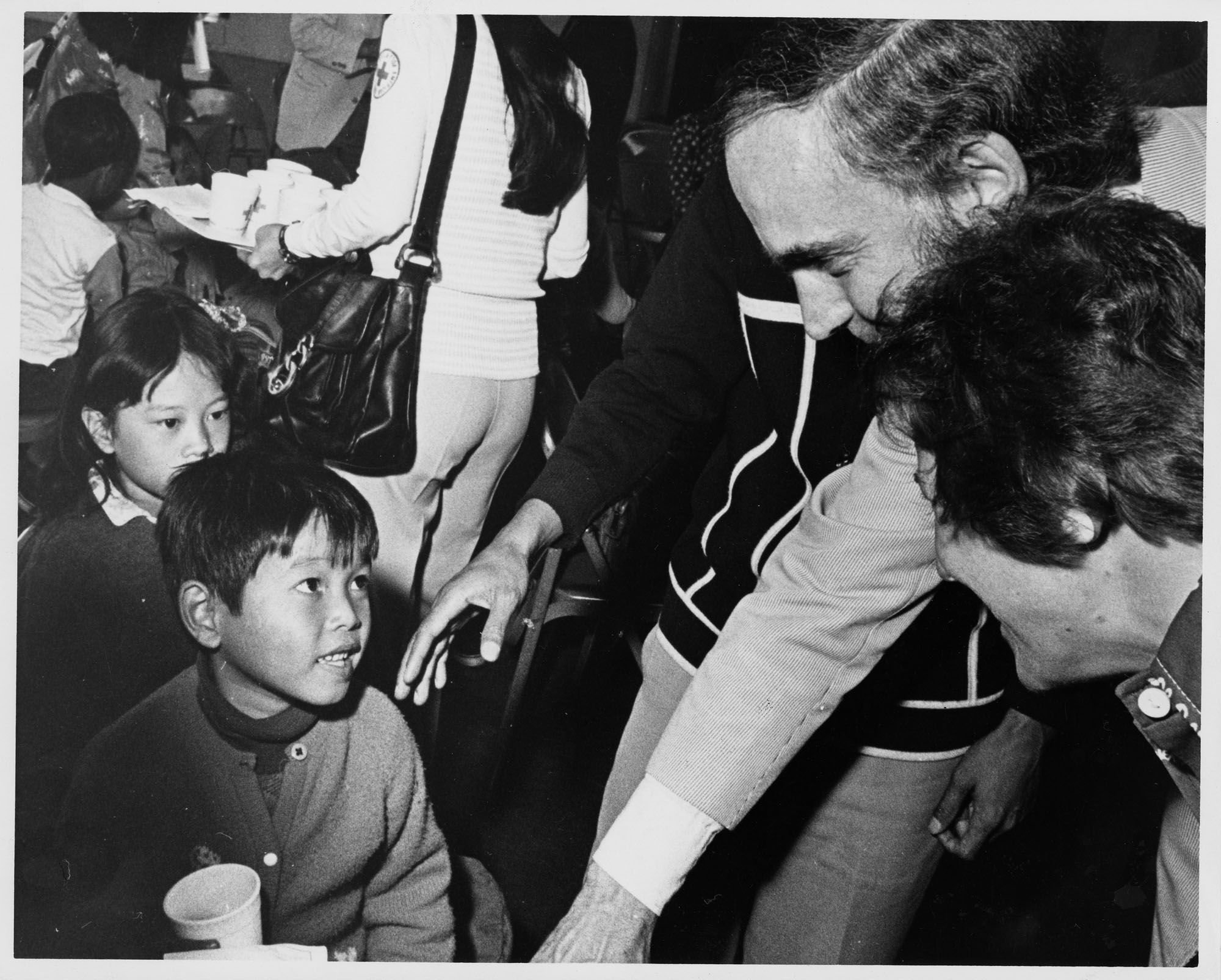 Image of Dan Evans greeting Vietnamese children at Camp Murray, Washington, May 20, 1975