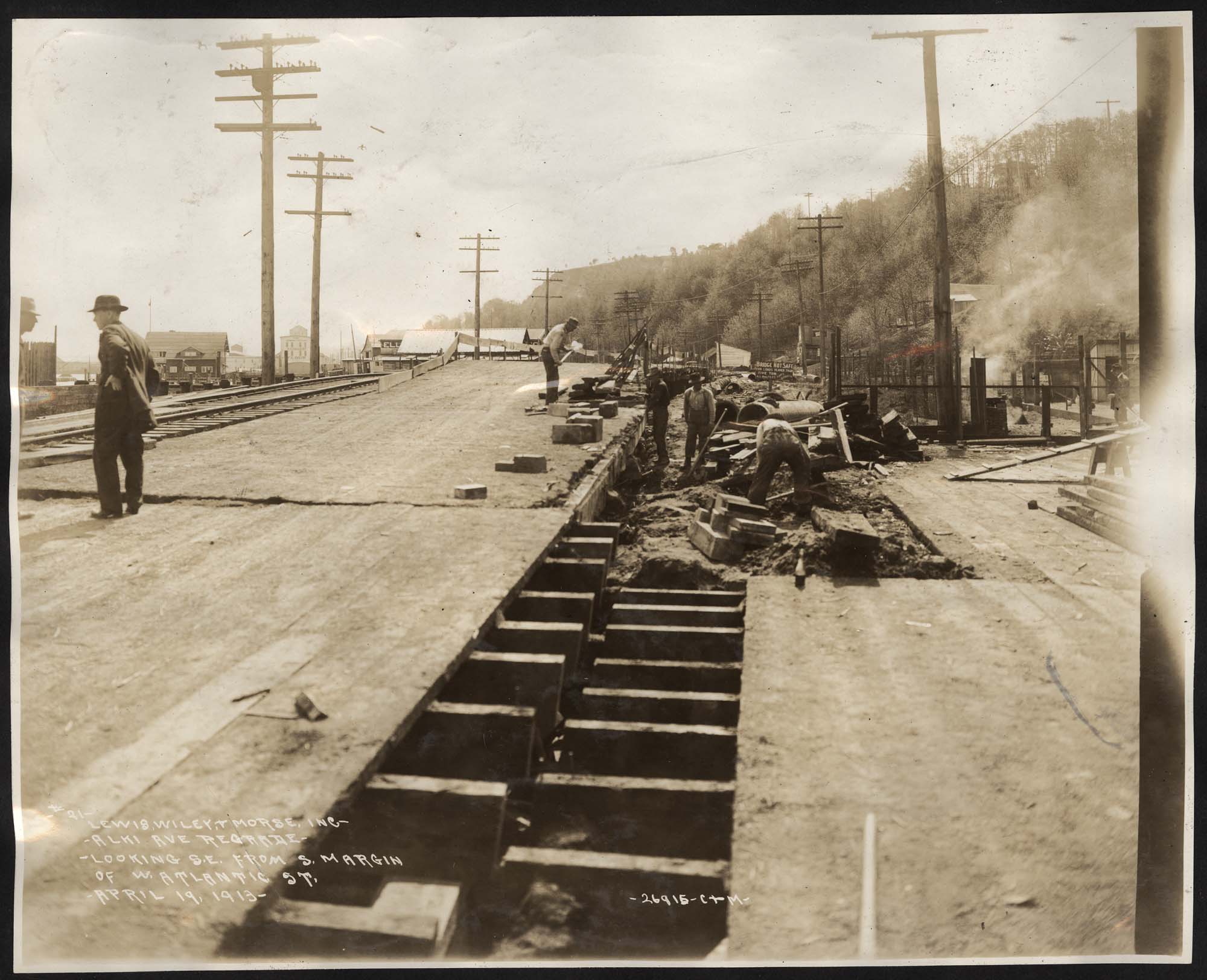 Image of Construction workers on plank road during Alki Avenue regrade, April 19, 1913