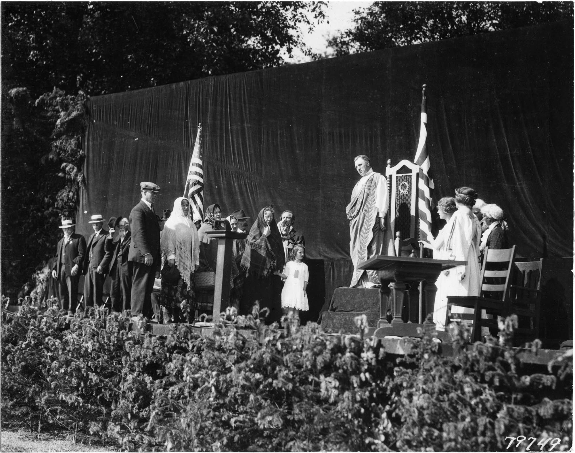 Image of Man in ancient Greek dress and other performers onstage during the 