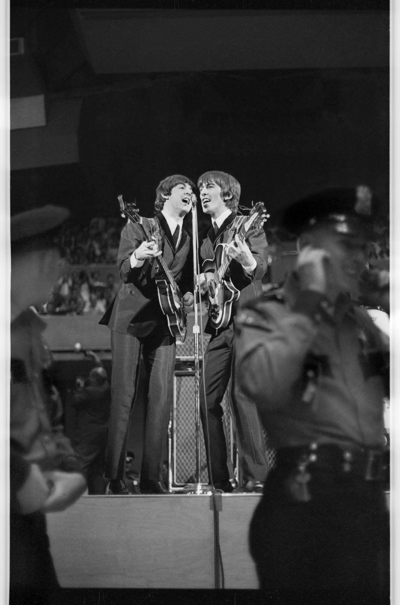 Image of Paul McCartney and George Harrison singing during the Beatles concert, Seattle Center Coliseum, August 21, 1964