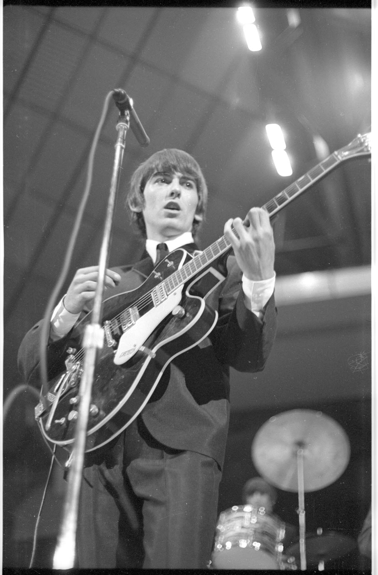 Image of George Harrison playing guitar at the Beatles concert, Seattle Center Coliseum, August 21, 1964