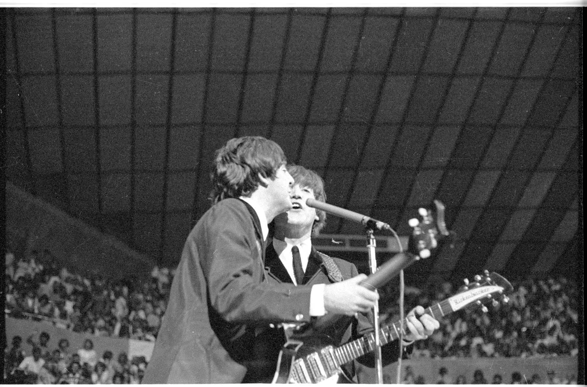 Image of Paul McCartney and John Lennon singing at the Beatles concert, Seattle Center Coliseum, August 21, 1964