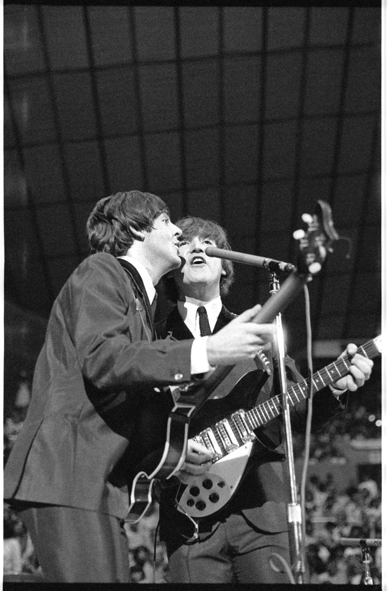 Image of Paul McCartney and John Lennon singing at the Beatles concert at Seattle Center Coliseum, August 21, 1964