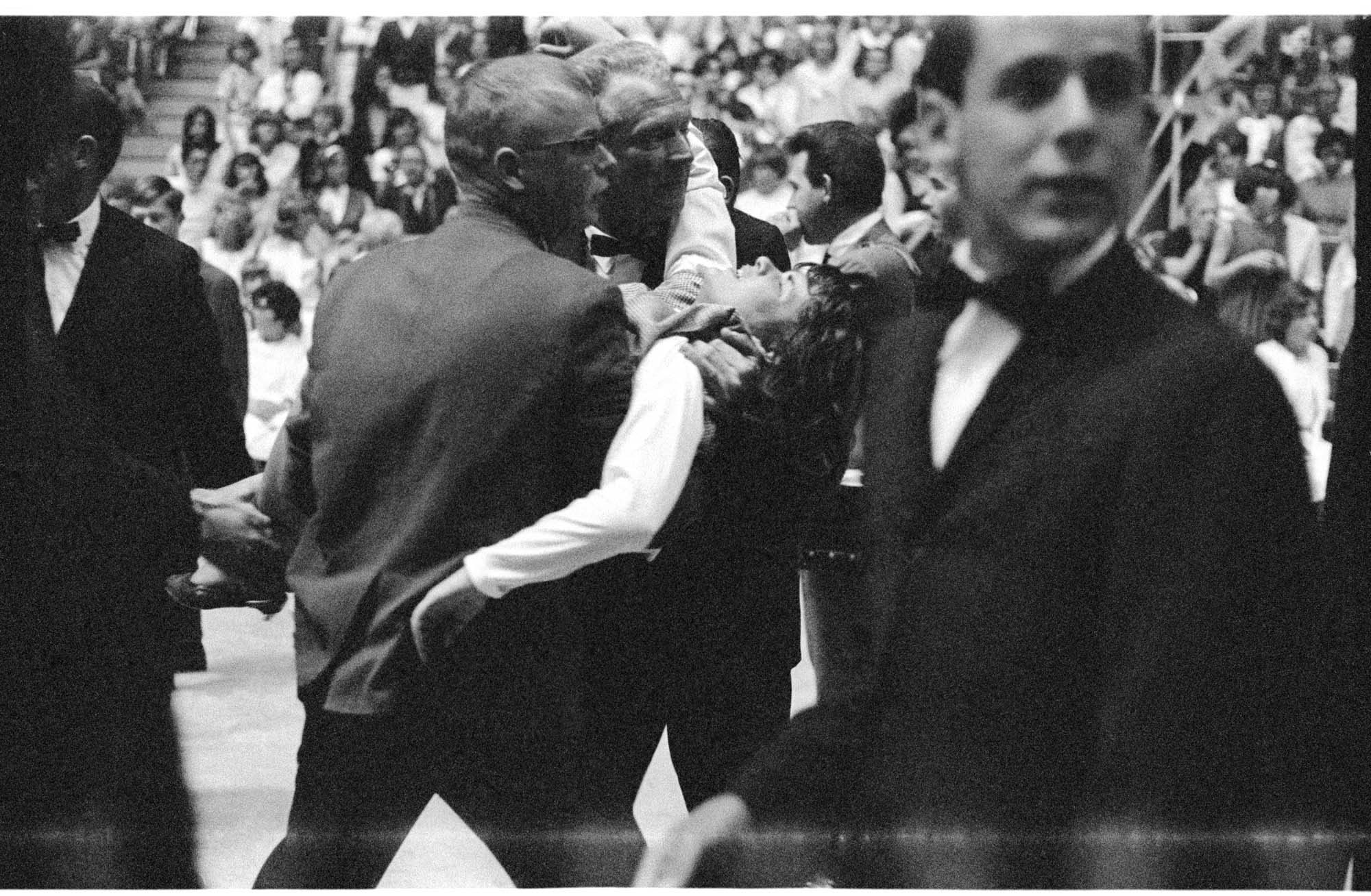 Image of Men carrying an overcome fan at the Beatles concert at Seattle Center Coliseum, August 21, 1964