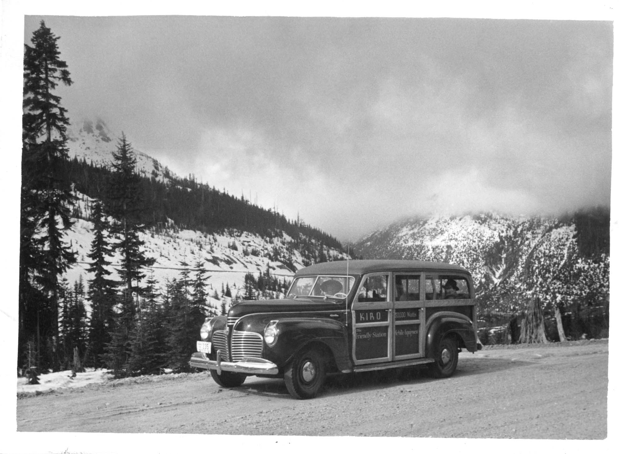 Image of KIRO mobile news station wagon parked on mountain road, circa 1942
