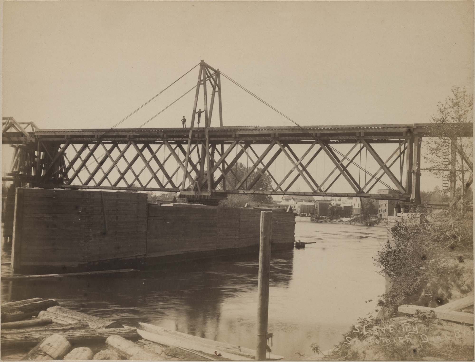 Image of Two men standing on Seattle, Lake Shore & Eastern railway drawbridge across Snohomish River, circa 1890