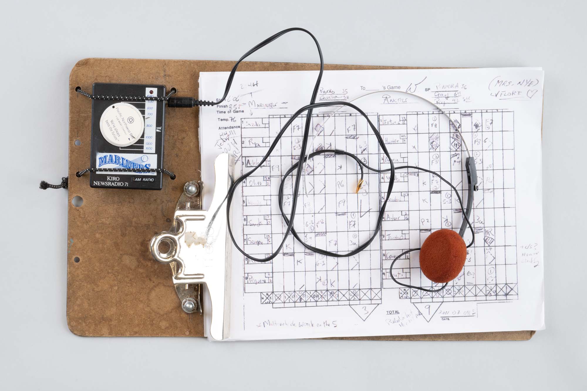 Image of Bill Nye’s baseball scoring clipboard and radio, 1980s-1990s