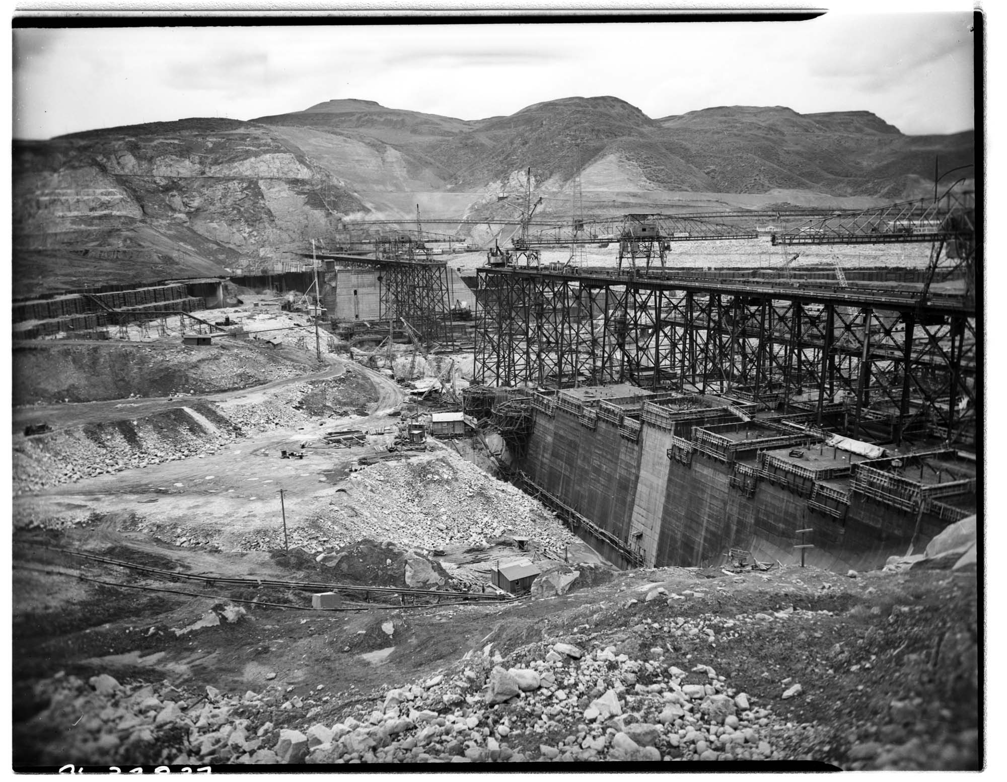 Image of Trestles and traveling cranes at dam construction site, circa 1937