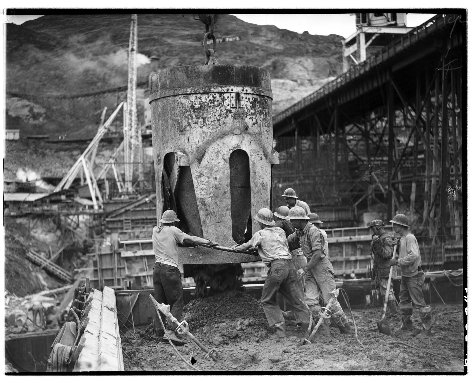 Image of Men emptying cement into form at dam construction site, circa 1937