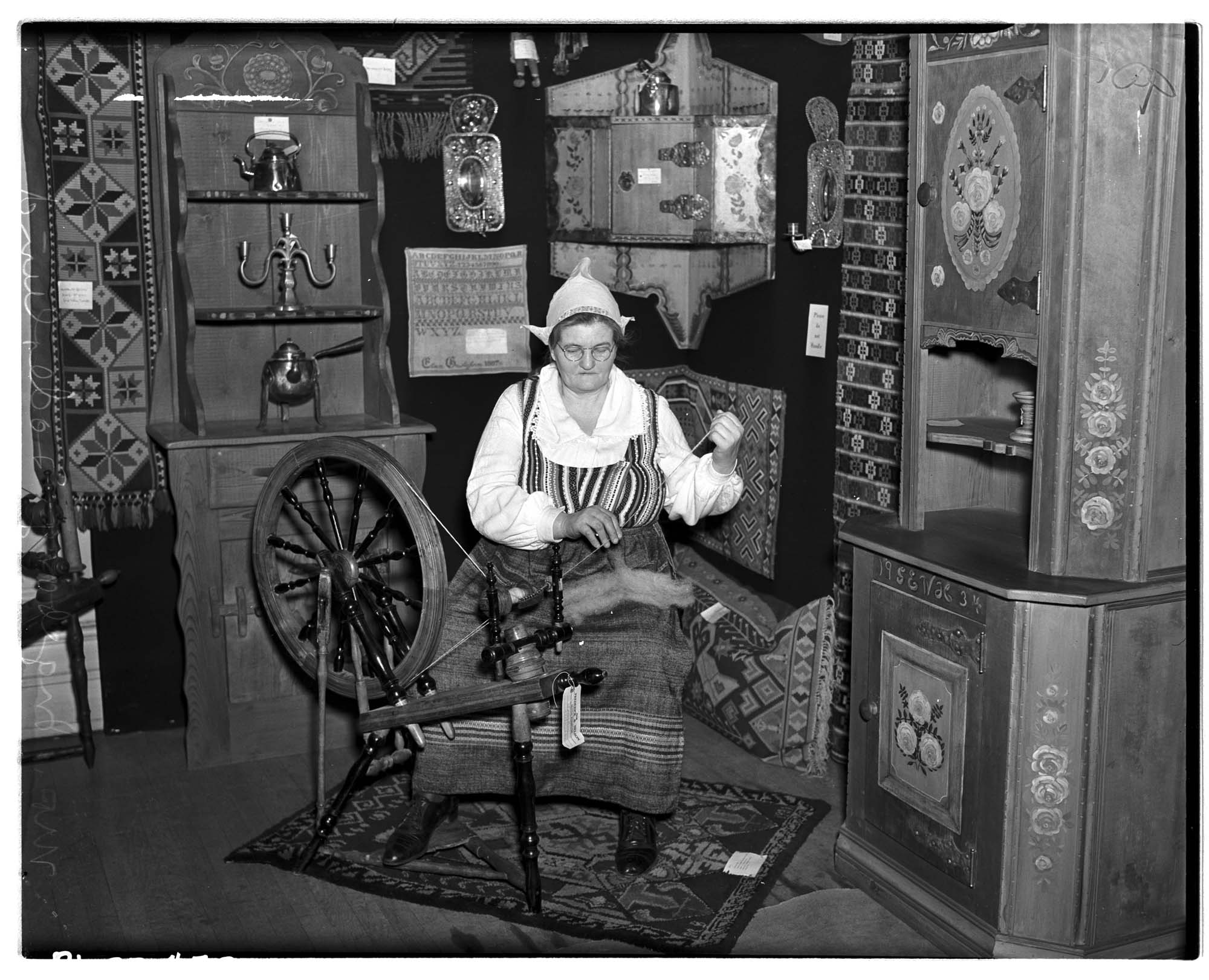 Image of Woman spinning in Swedish Folk Art exhibition, February 1937