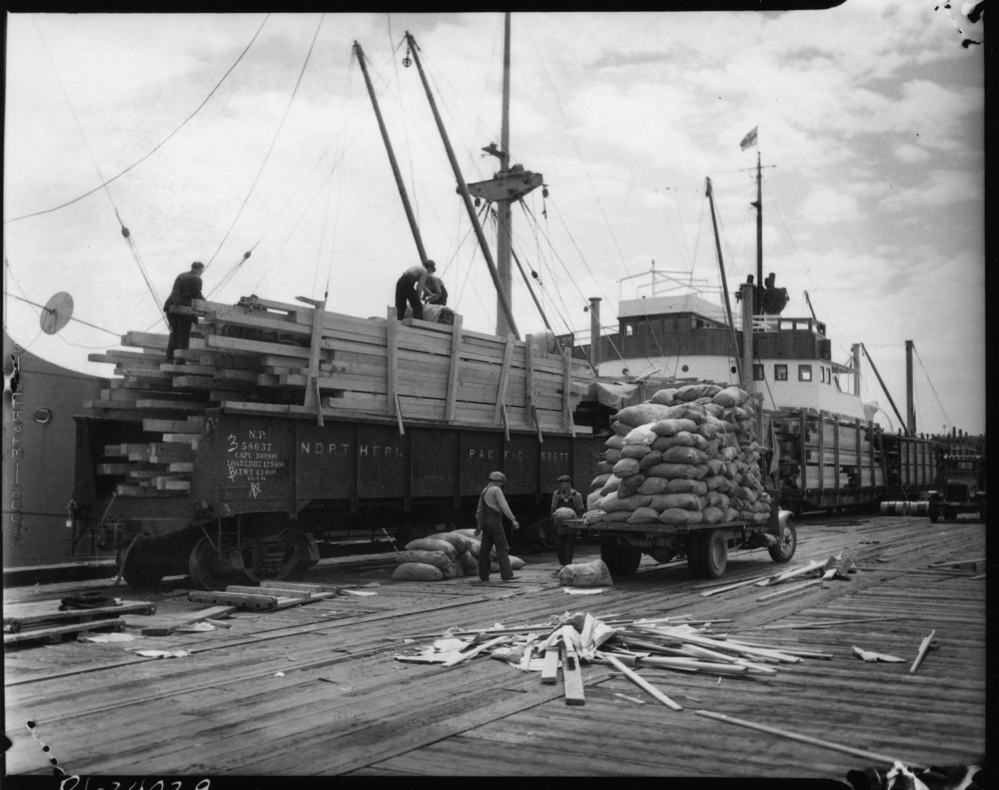 Image of Truck and railroad car with cargo, Seattle, 1934