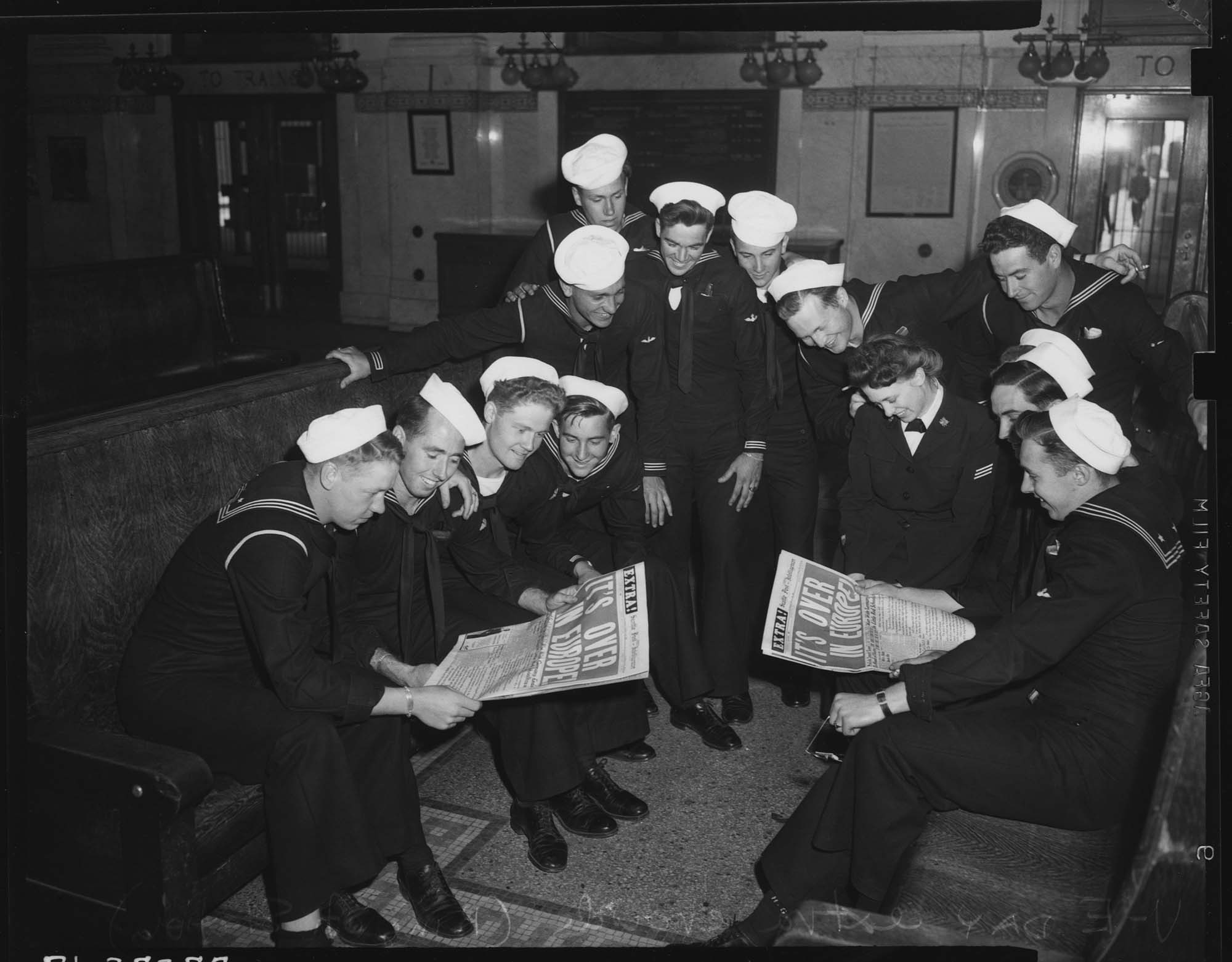Image of Sailors looking at V-E Day newspaper, May 1945